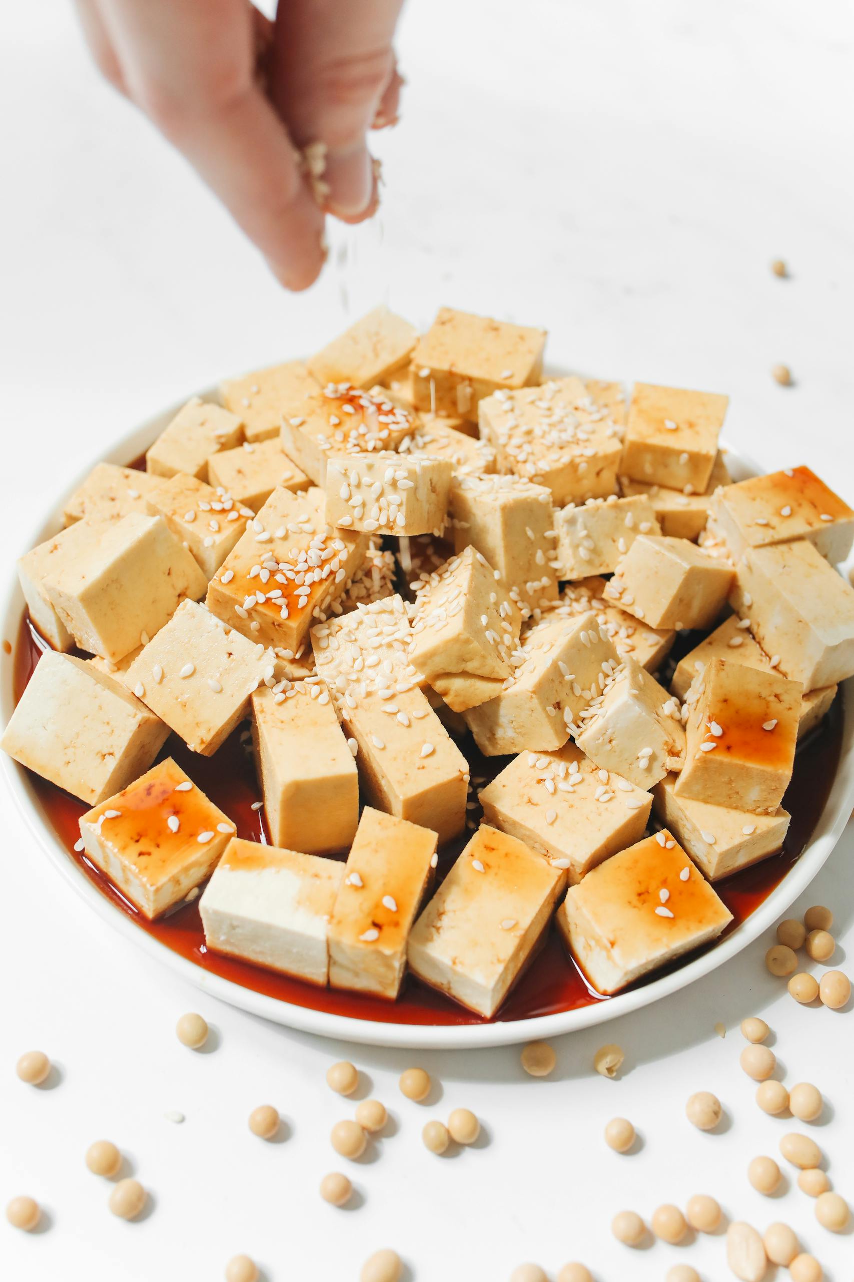 do GLP-1s cause muscle loss? Delicious tofu cubes drizzled with soy sauce and sprinkled with sesame seeds, perfect for a healthy meal.