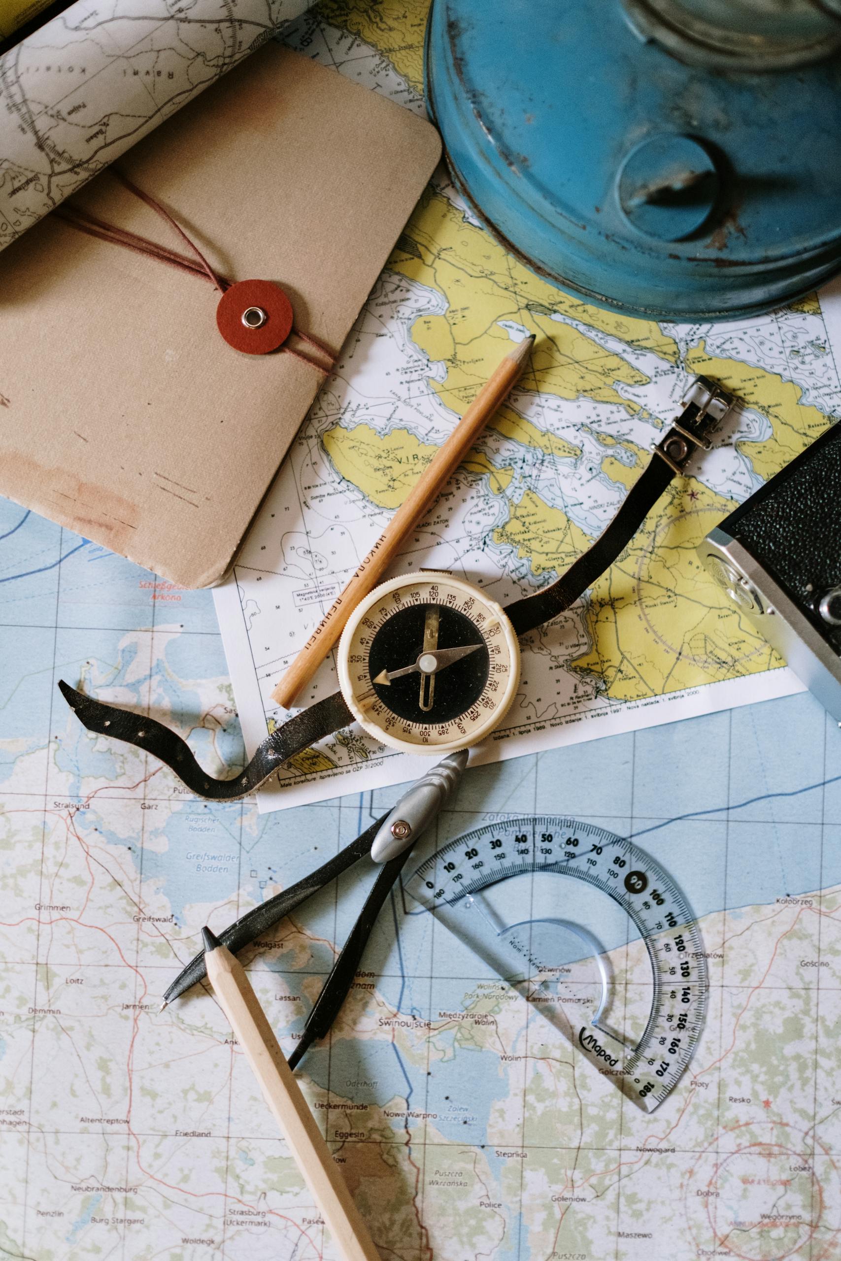 staying healthy while traveling: Flat lay of vintage compass, protractor, and maps for navigation study.