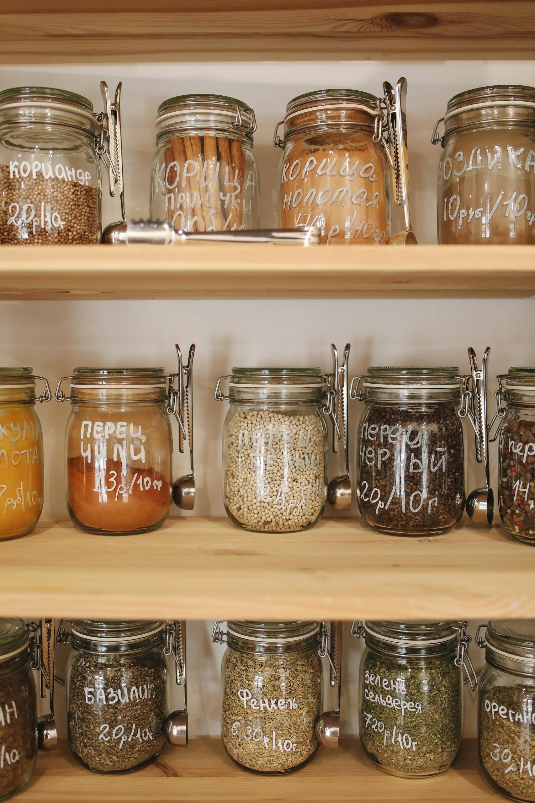 Rustic wooden shelves with assorted spices and ingredients stored in labeled glass jars for zero-waste storage.