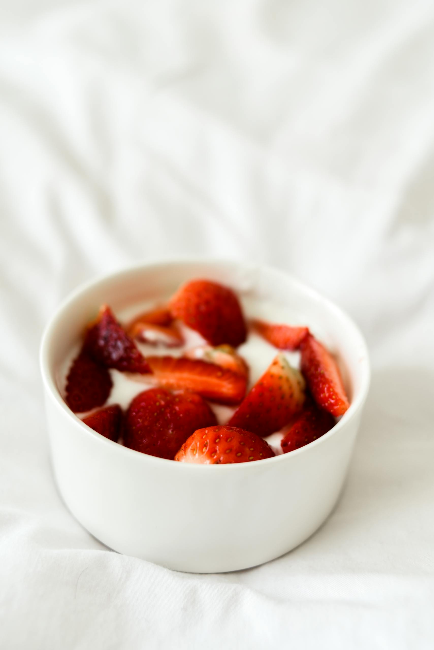best foods for longevity: A delicious bowl of fresh strawberries with yogurt, showcasing a healthy and tasty breakfast option.