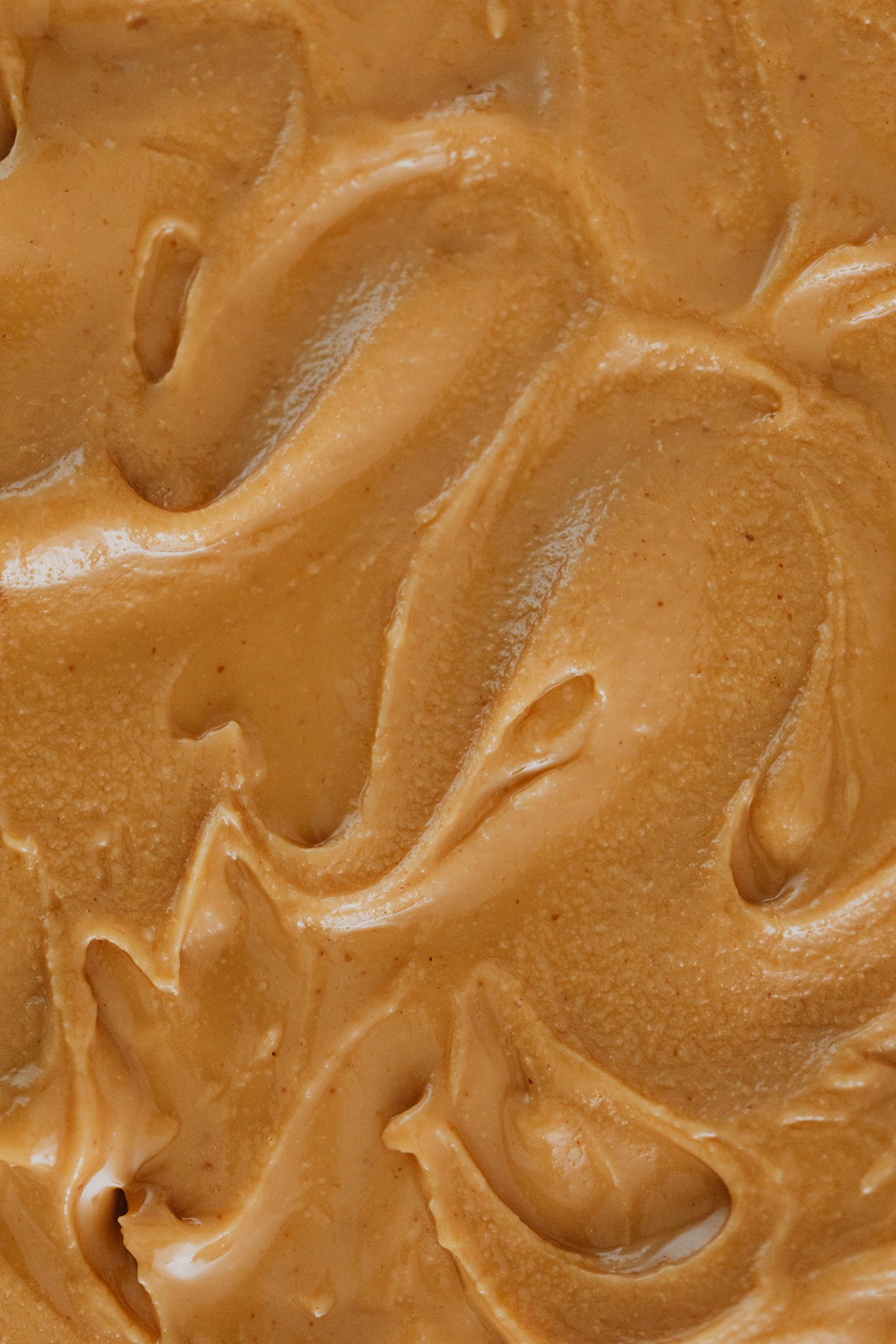 high-protein vegan snacks: A detailed close-up of creamy peanut butter swirls, perfect for food lovers.