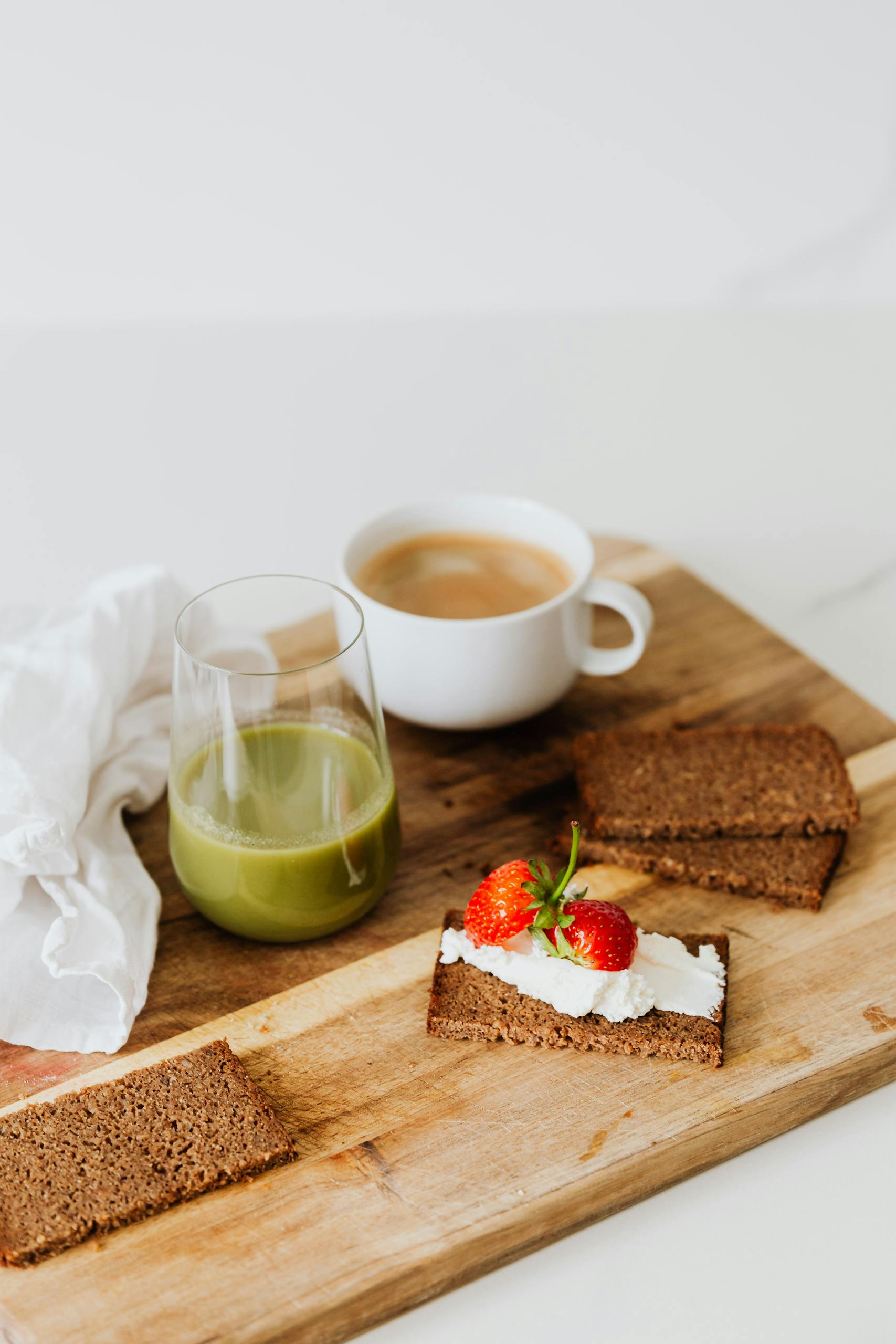 high-protein breakfast options at Target: Appetizing breakfast with rye bread, green juice, and strawberries on a wooden tray.