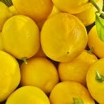 Bright yellow lemons perfectly captured with a single green leaf, conveying freshness and vitality.
