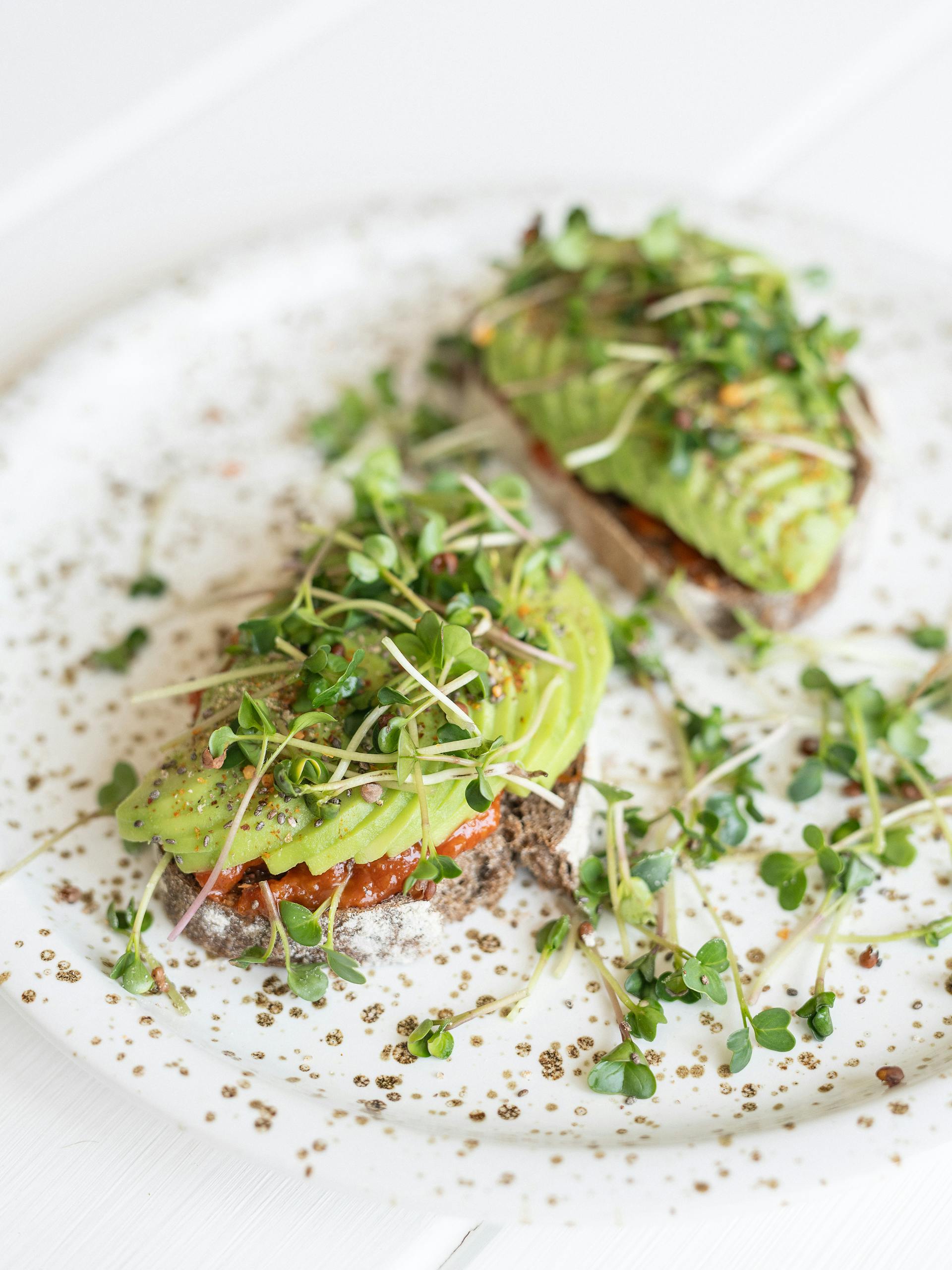 Foods That Help With PMS Symptoms: Delicious avocado toast topped with fresh microgreens, perfect for a healthy meal.