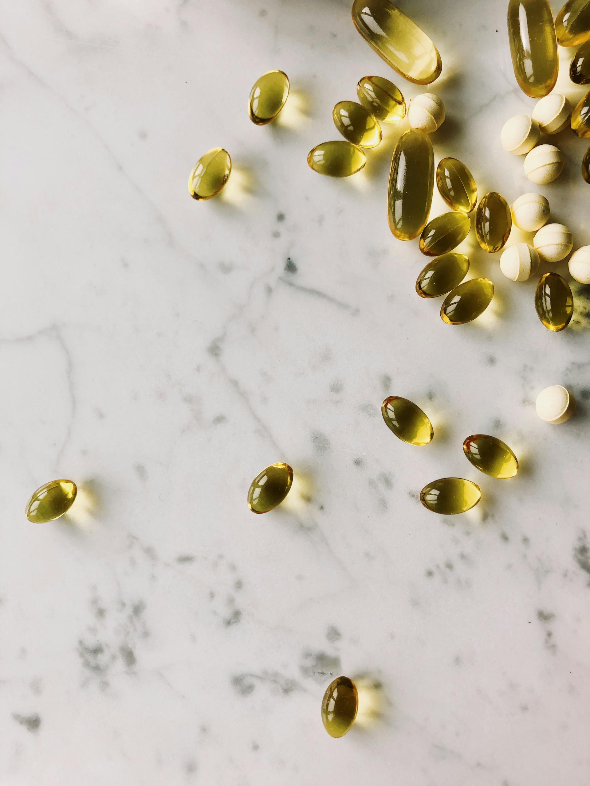zinc and hormones: Assorted capsules and pills on a marble surface, perfect for healthcare and pharmaceutical themes.