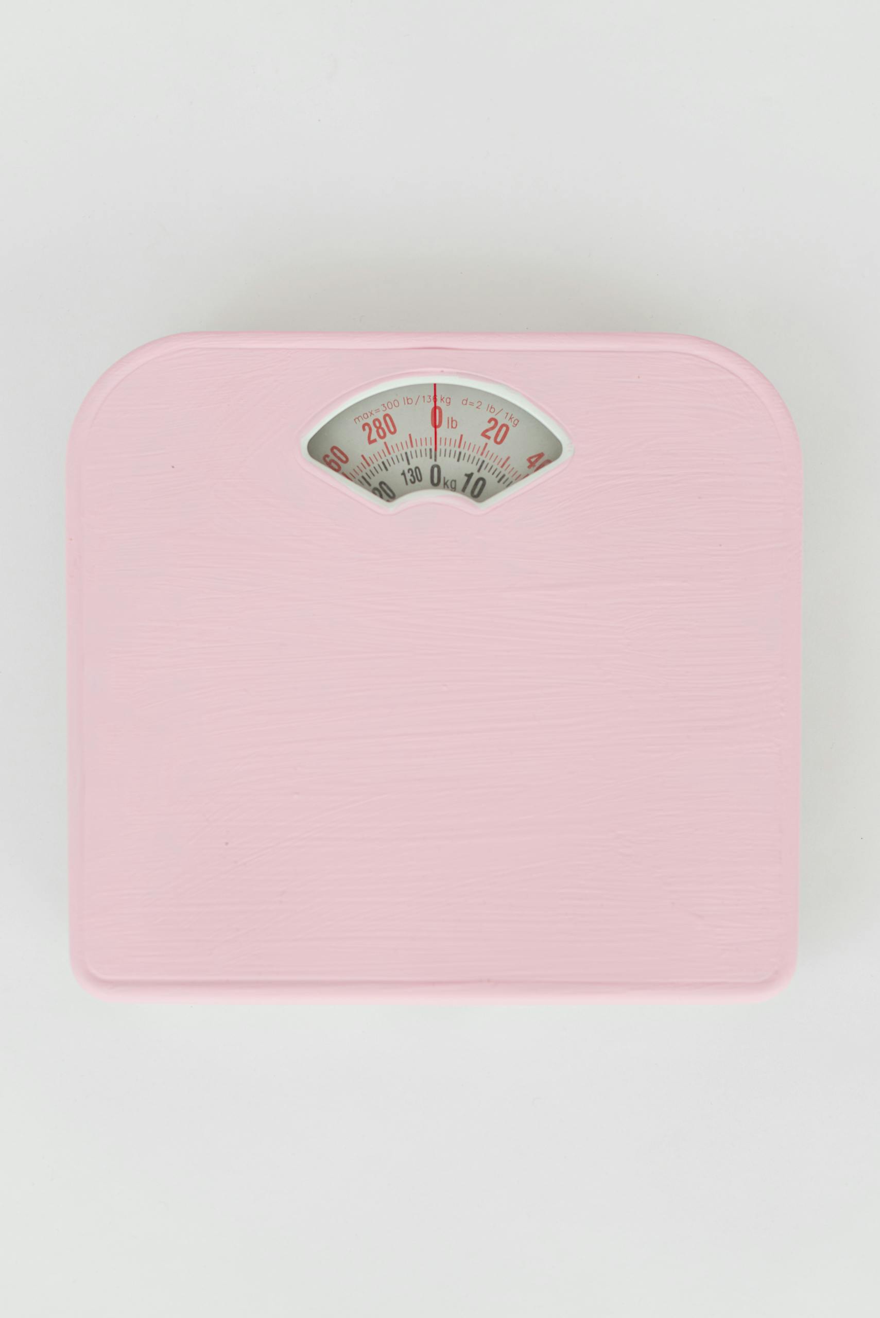 not losing weight on glp-1: Top view of scales for checking weight and controlling health on white background
