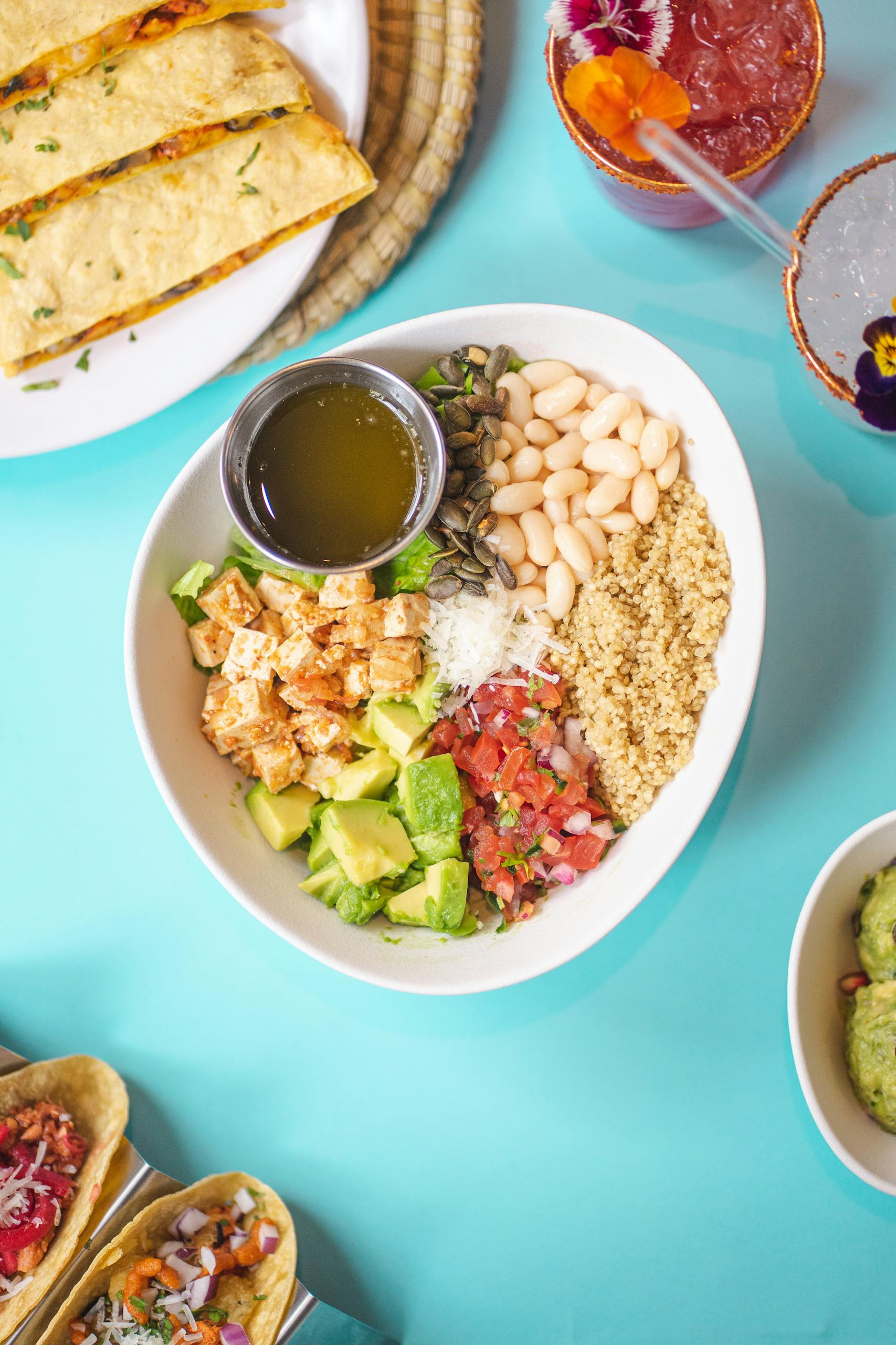 how to eat more fiber without bloating: Colorful Mexican-inspired bowl with beans, avocado, and quinoa.