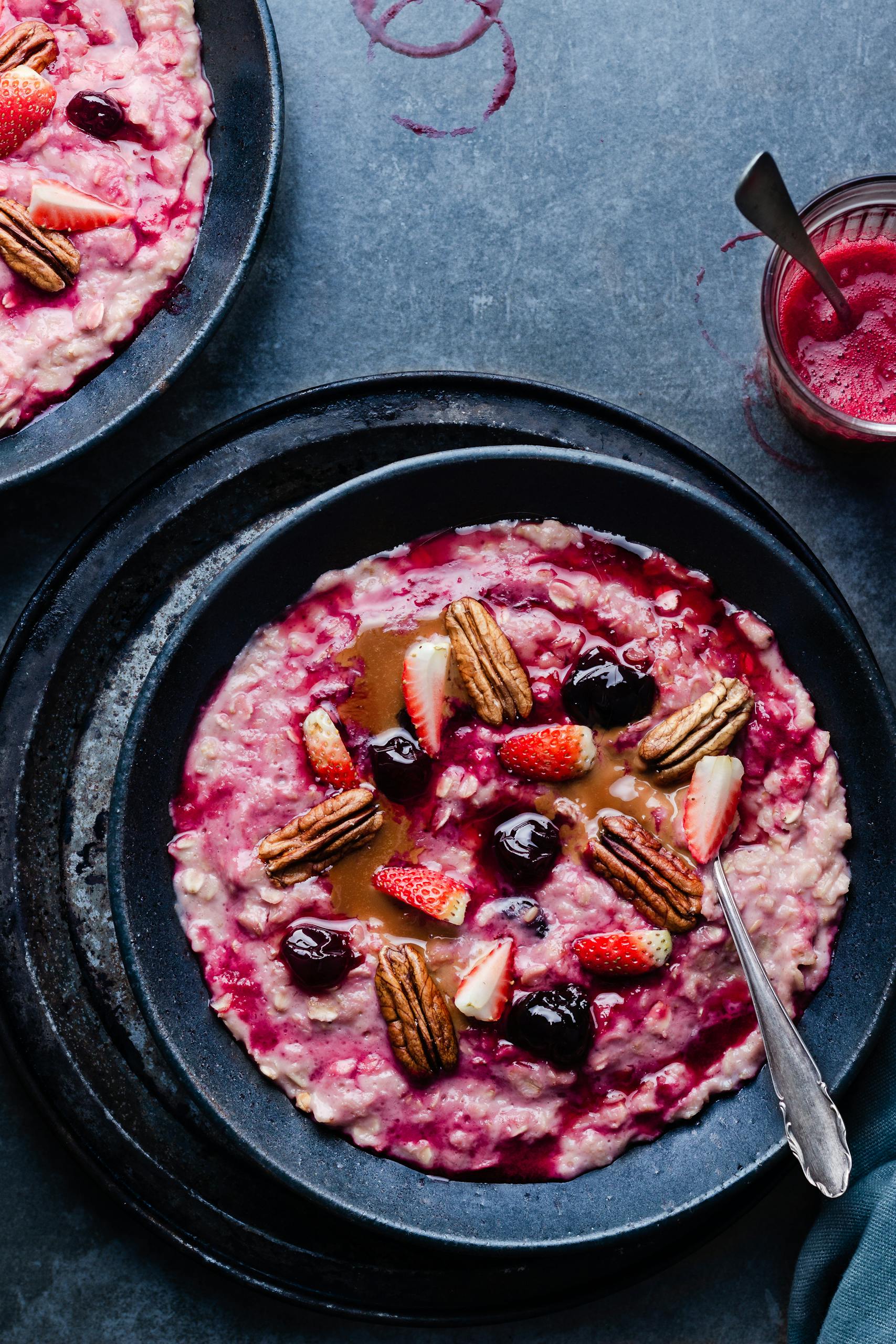 how to eat more fiber without bloating: Delicious breakfast oatmeal with strawberries, cherries, and pecans in a vibrant setting.