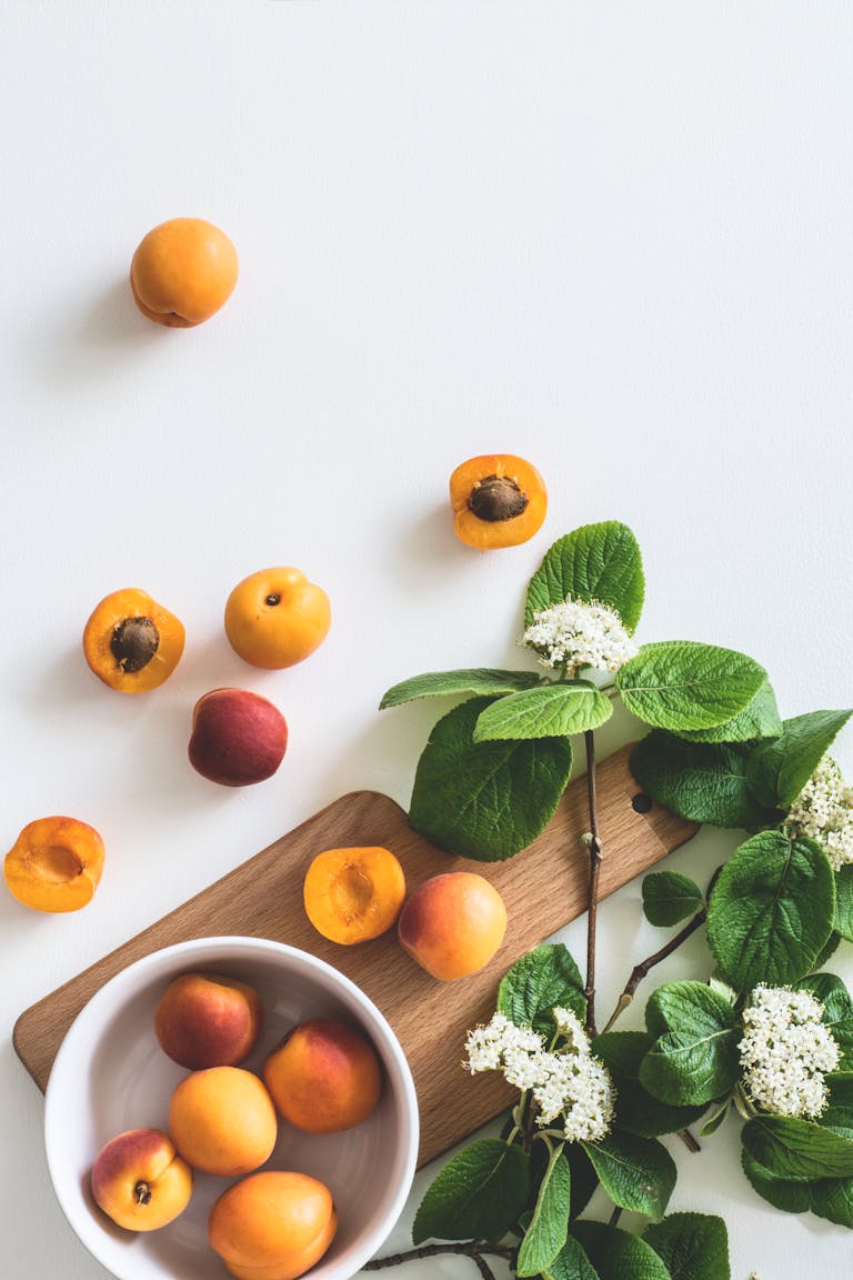 starvation mode: A flat lay of fresh apricots and blossoms on a board showcasing summer freshness.