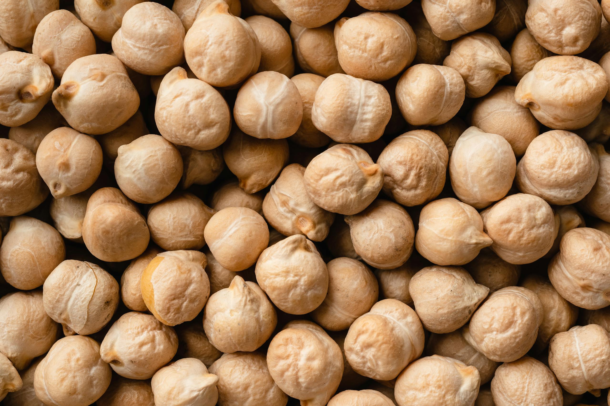 30 grams of fiber a day: Detailed close-up image of raw chickpeas, highlighting texture and natural color.