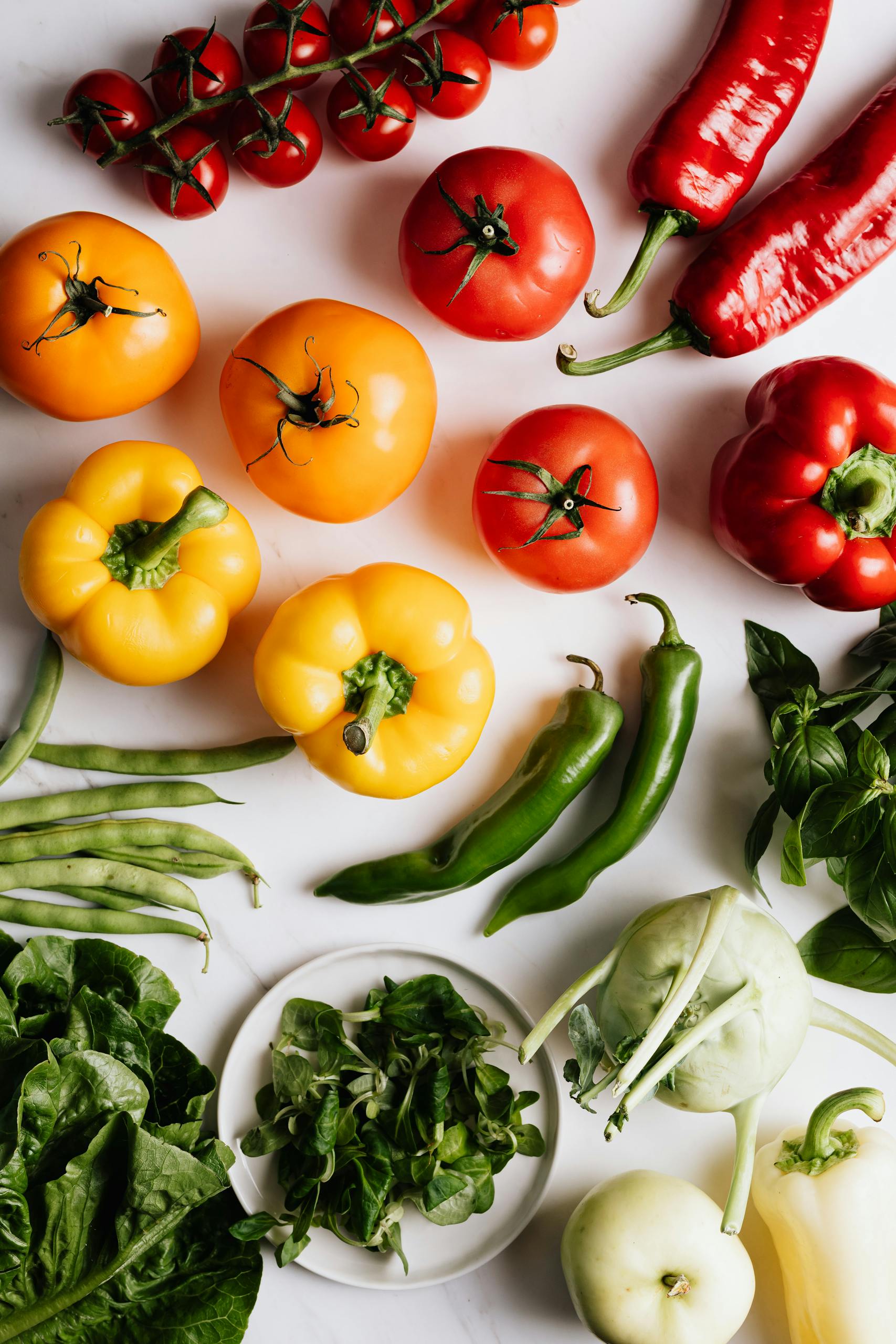 best foods for hormone balance: Vibrant top view arrangement of mixed fresh vegetables including peppers and tomatoes.