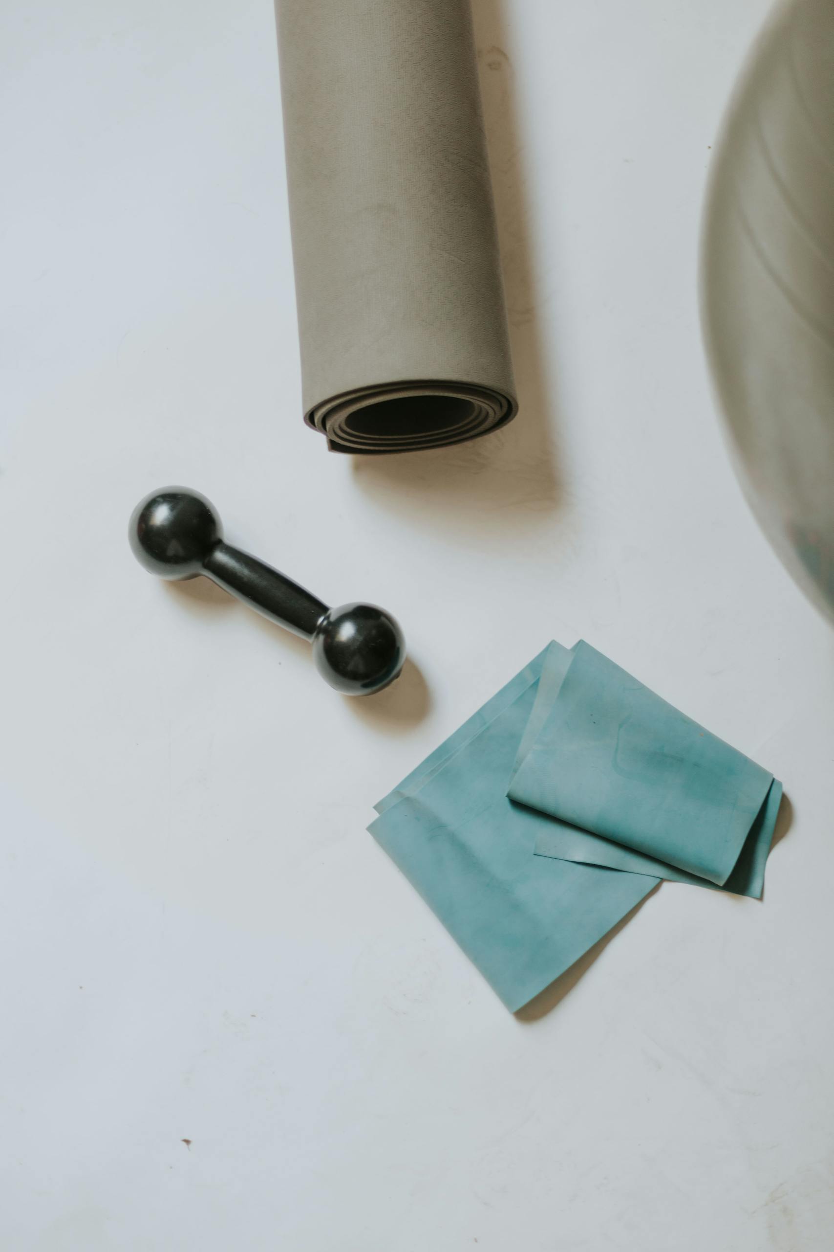 fasted cardio for fat loss: A flat lay of home workout essentials including a mat, dumbbell, and resistance band.