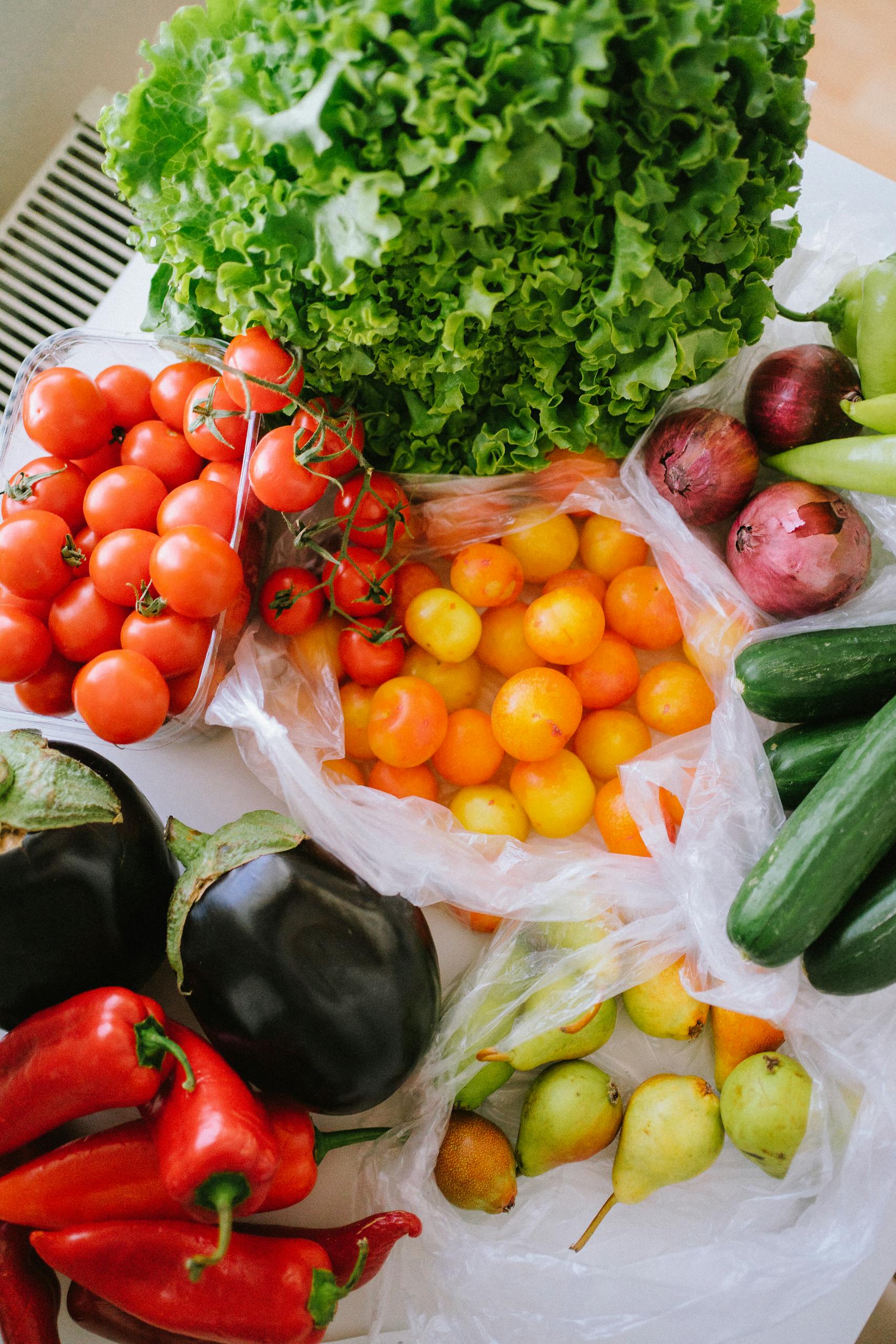 healthier alternatives to keto: A vibrant assortment of fresh vegetables including tomatoes, peppers, cucumbers, and lettuce displayed on a table.