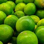 A vibrant collection of fresh, organic limes showcasing their rich green color and texture.