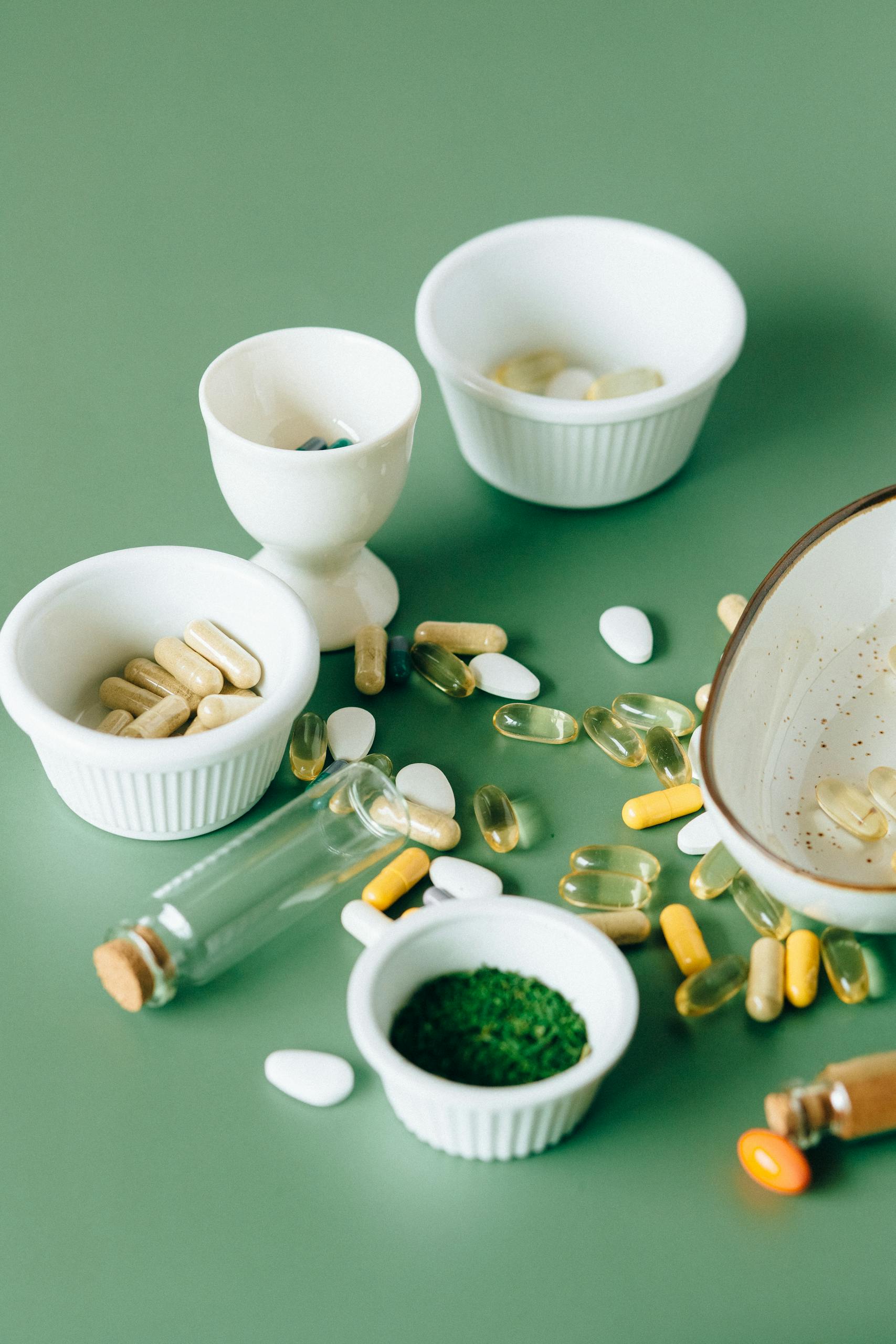 best supplements for brain health: Assorted natural supplements and pills in ceramic bowls on a green background, showcasing health and wellness themes.