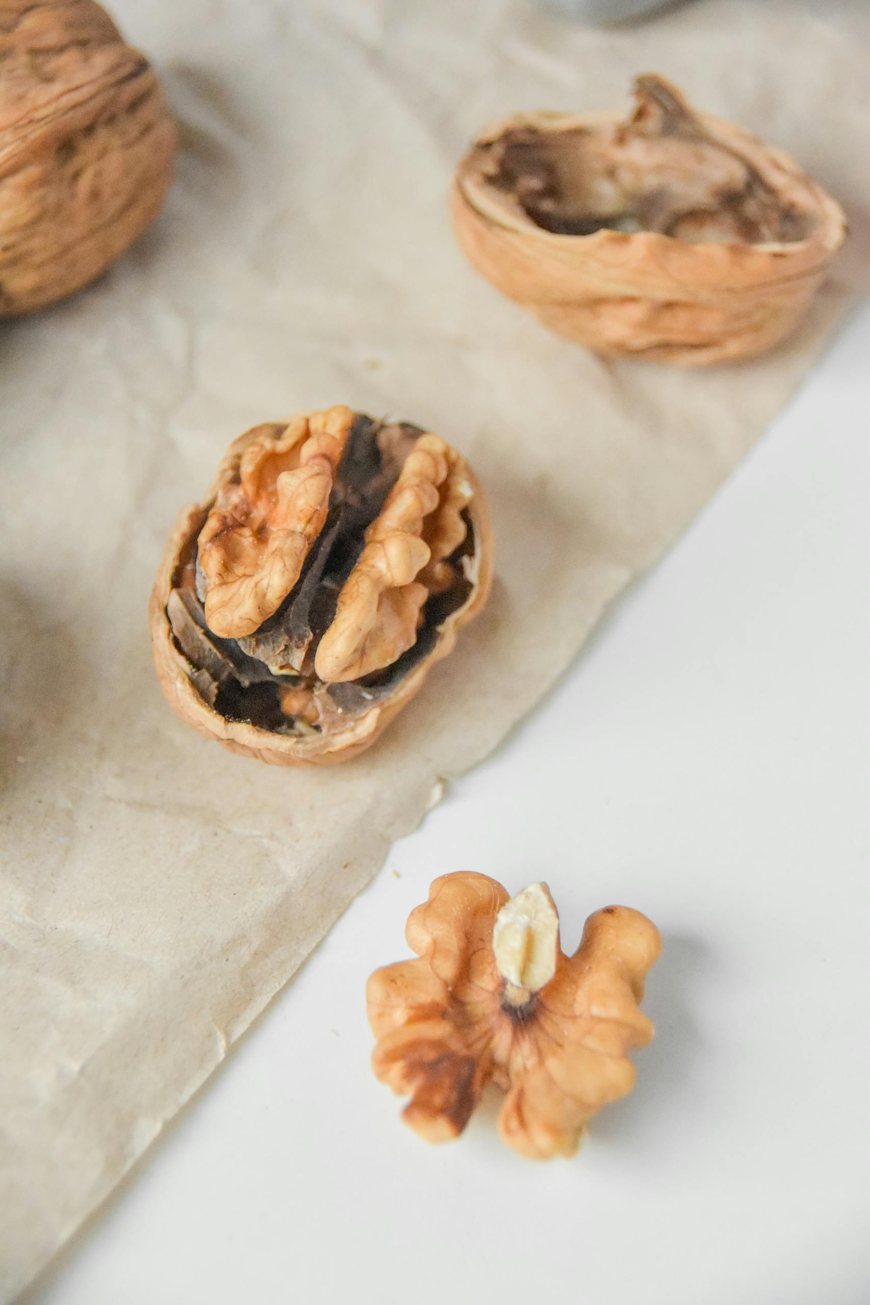 best foods to reduce brain fog: High-quality close-up of walnuts on parchment paper, highlighting texture and details.