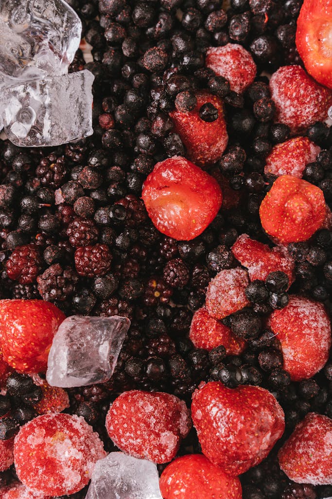 Healthiest Frozen Foods from Trader Joe's: Close-up of frozen strawberries, blackberries, and blueberries with ice cubes.
