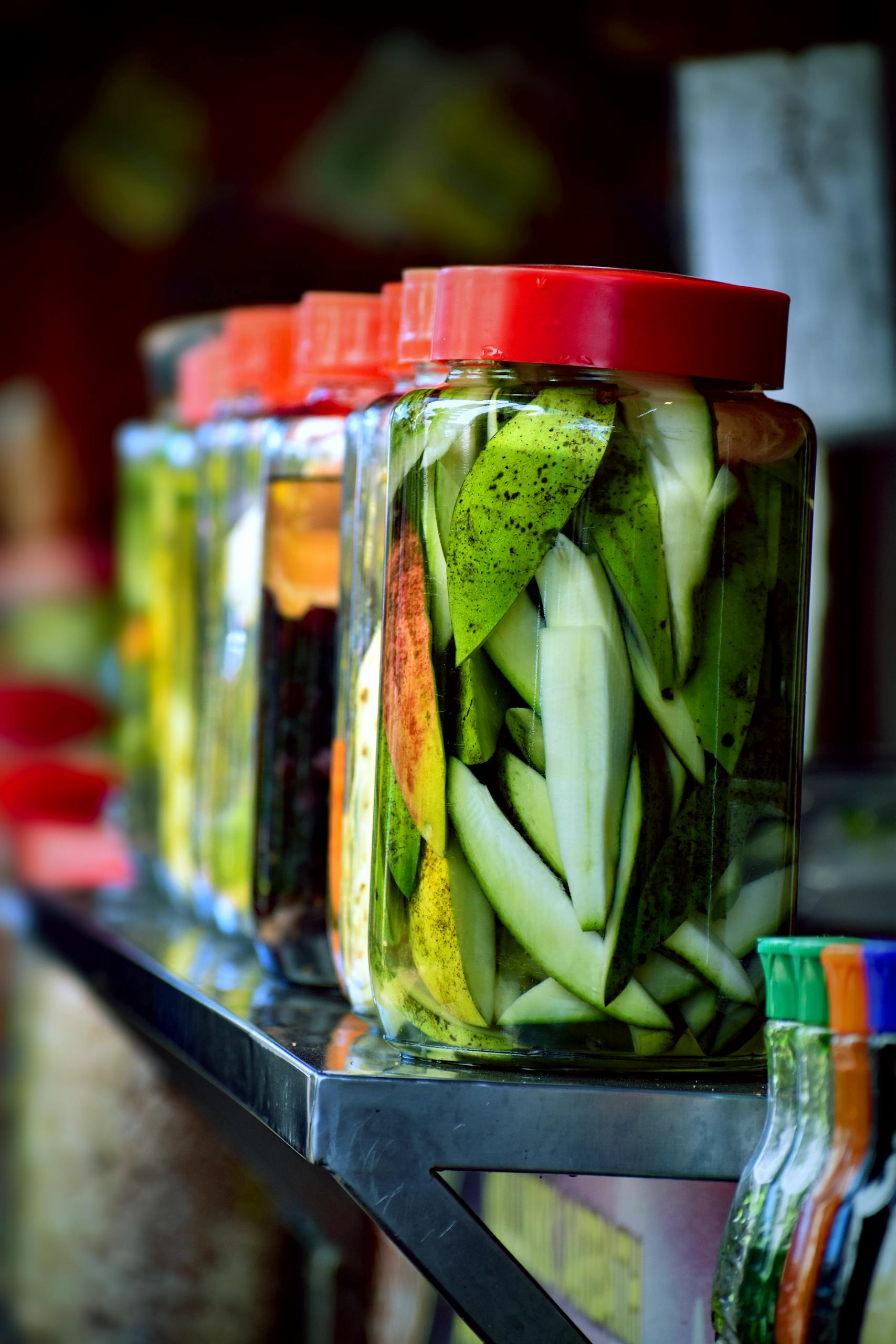 Nutrition Habits for Brain Health: Colorful jars of pickled mangoes showcasing vibrant tropical fruit preserved in brine.
