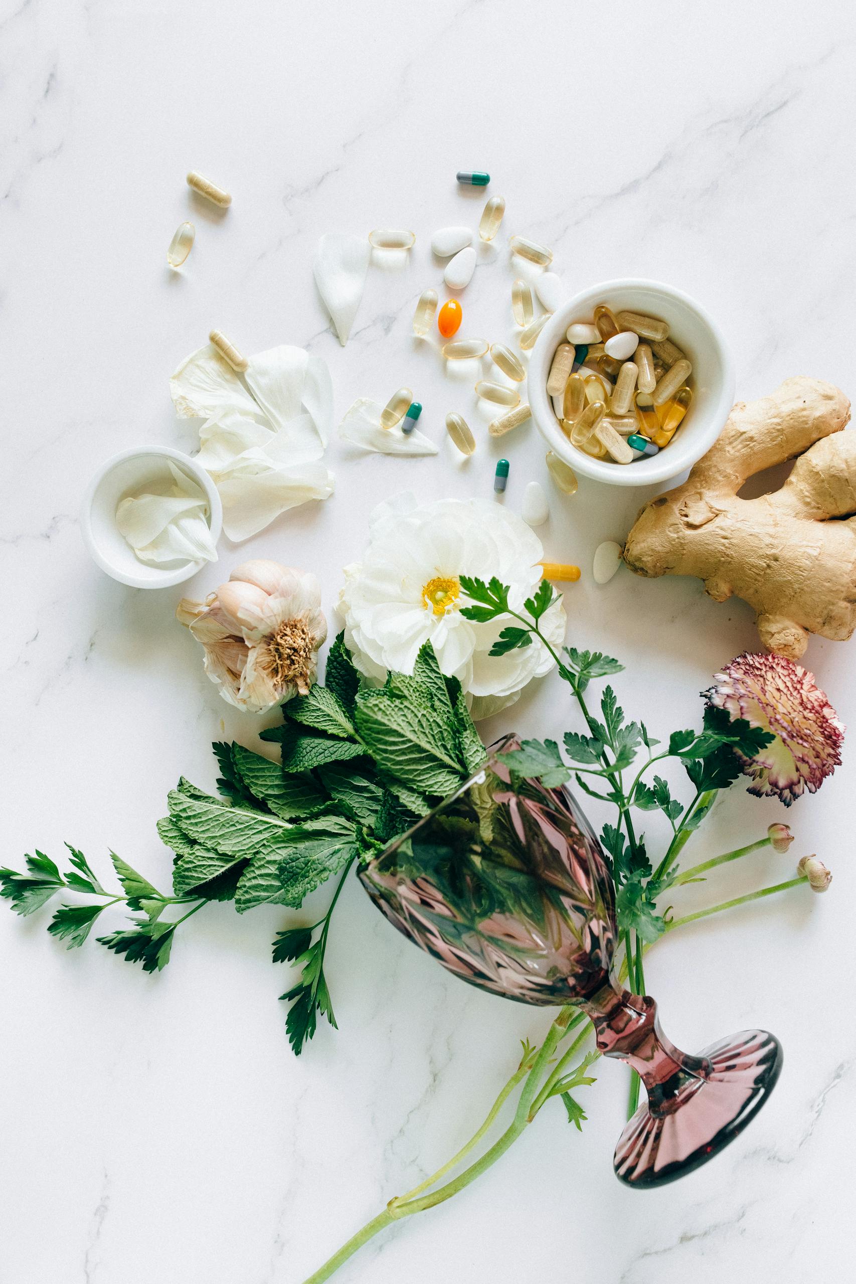 best supplements for brain health: Flat lay of herbs, supplements, and ginger on a marble surface, representing natural healthcare.