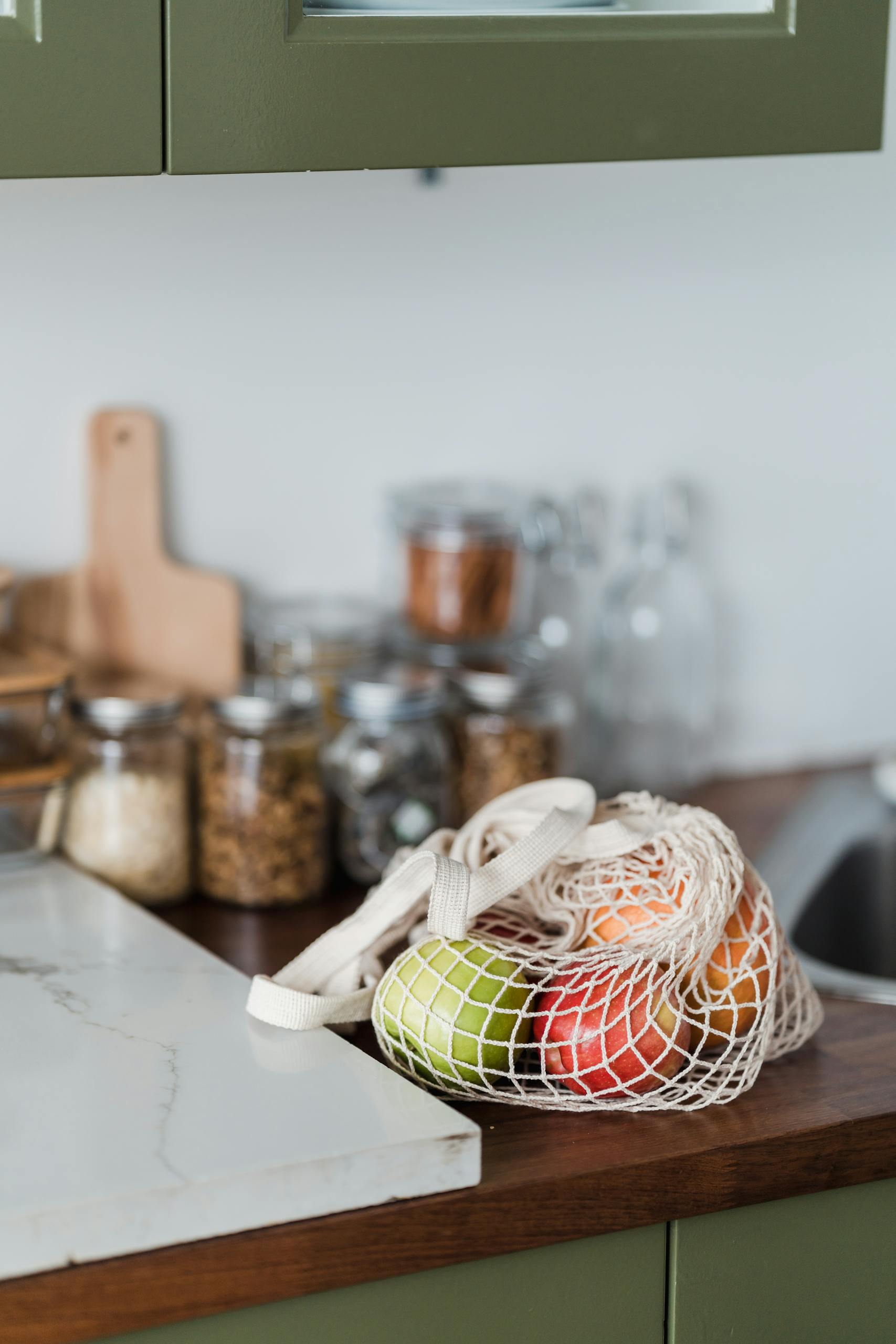 Nutrition Habits for Brain Health: Fresh fruits in a mesh bag on a kitchen counter, promoting sustainability and zero waste lifestyle.