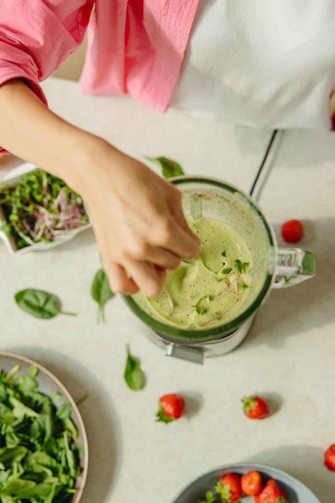 high-protein vegan snacks: Overhead view of a healthy green smoothie preparation with fresh ingredients.
