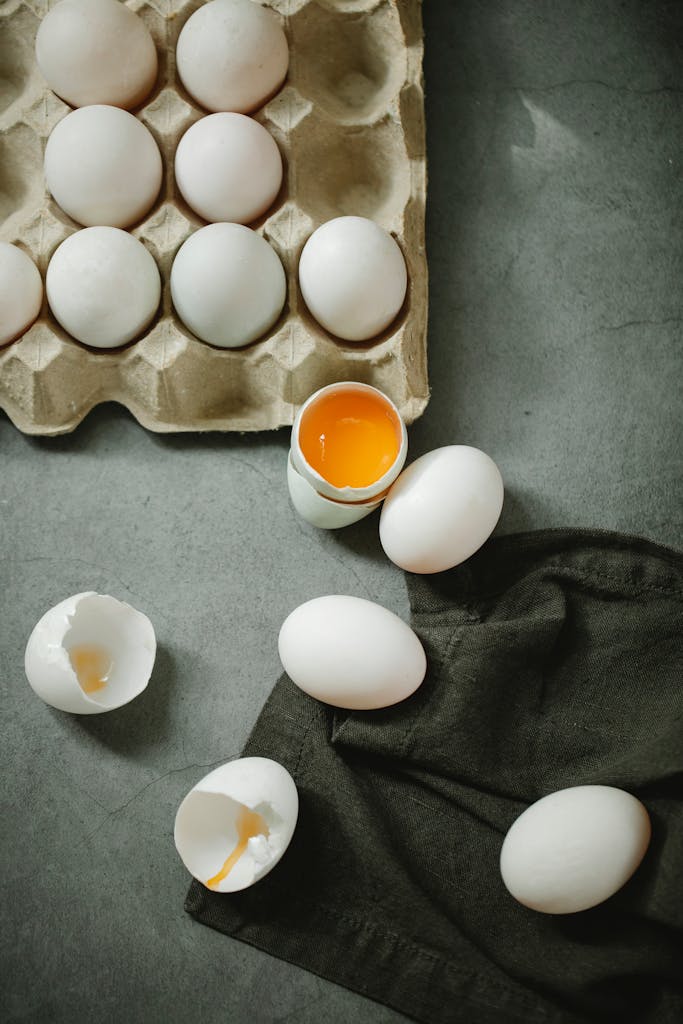 high-protein breakfast options at Target: Top view composition of raw organic eggs placed in egg carton and scattered on dark table in kitchen