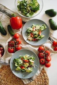 healthier alternatives to keto: Top view of a vibrant vegetable salad featuring fresh ingredients on plates and a towel.