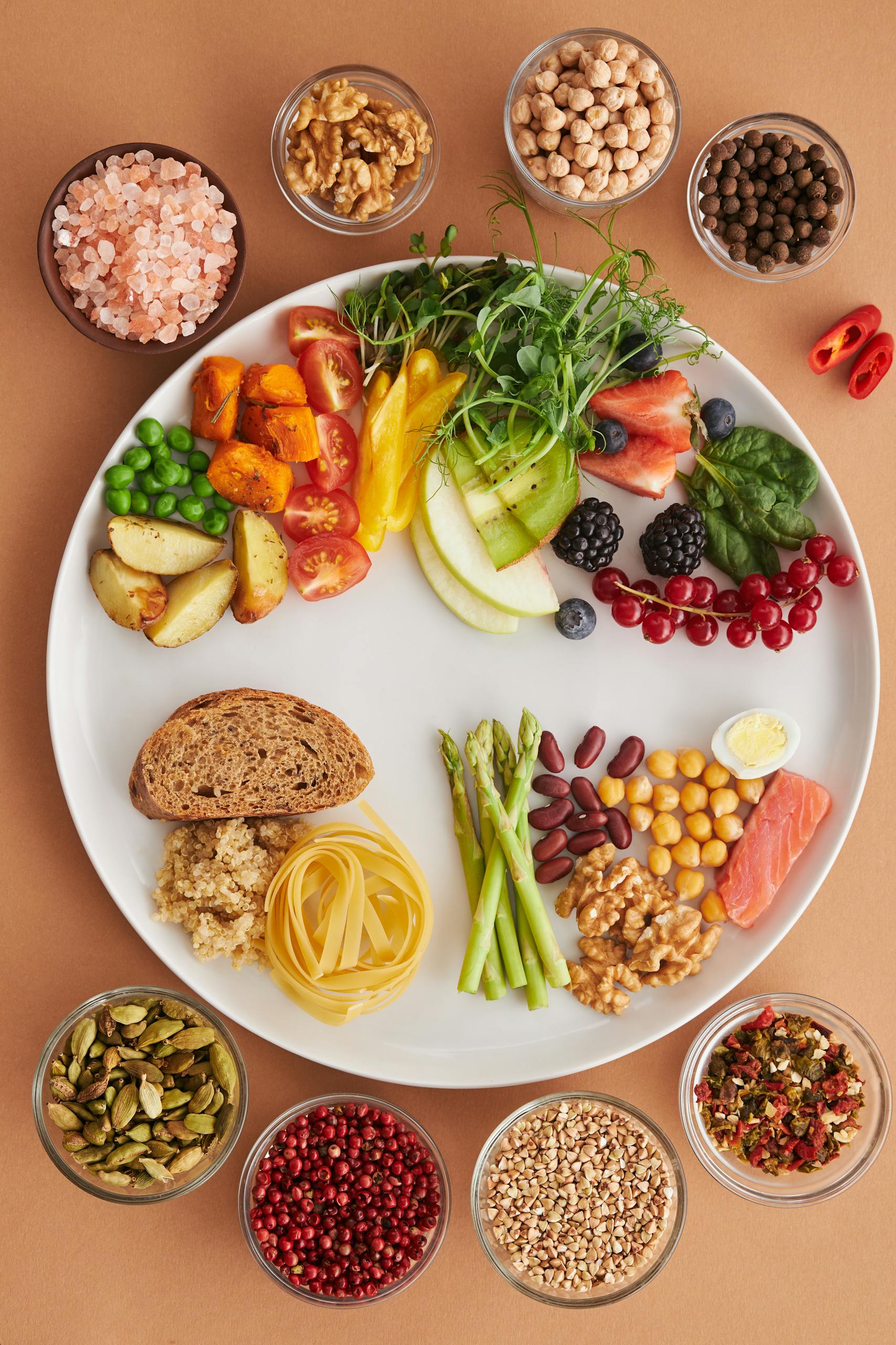 why fad diets cause weight regain: A vibrant assortment of healthy foods on a plate, showcasing a balanced diet with fruits, vegetables, nuts, and grains.