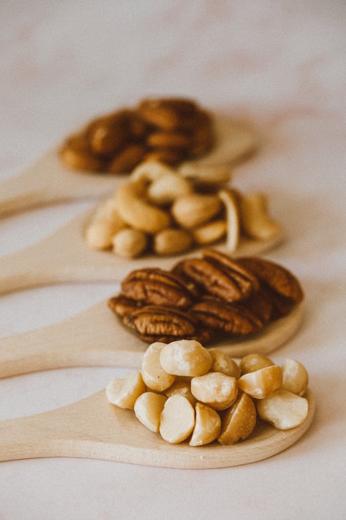 How to Make Meals Healthier: Close-up of assorted nuts on wooden spoons, highlighting variety and nutrition.