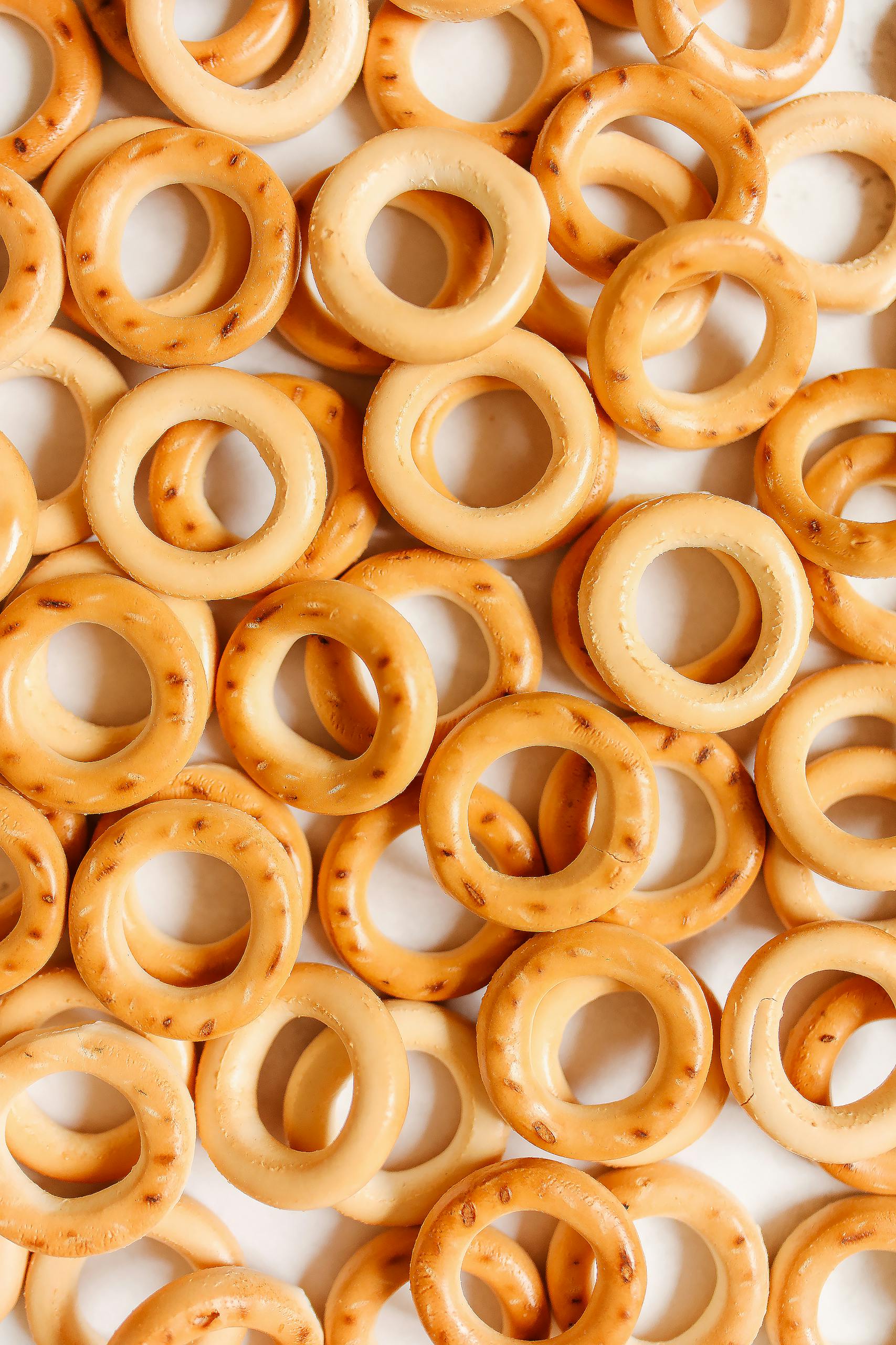 Are Ultra-Processed Foods Always Unhealthy: Close-up of freshly baked round bagels with golden crusts in a flat lay arrangement for bakery promotions.