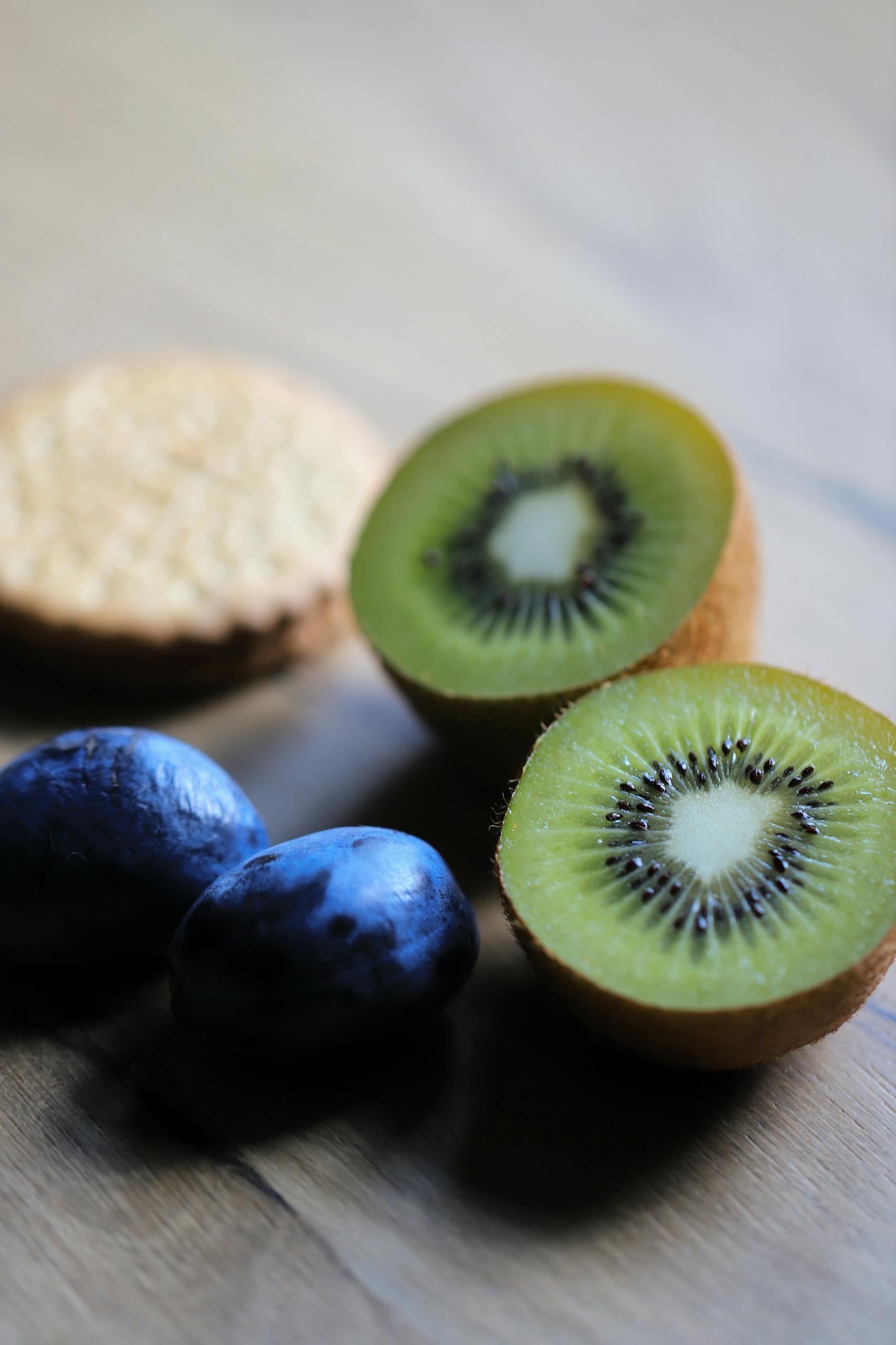 Healthy Costco Snacks: Close-up of sliced kiwi, plums, and biscuits on a wooden surface with natural light.