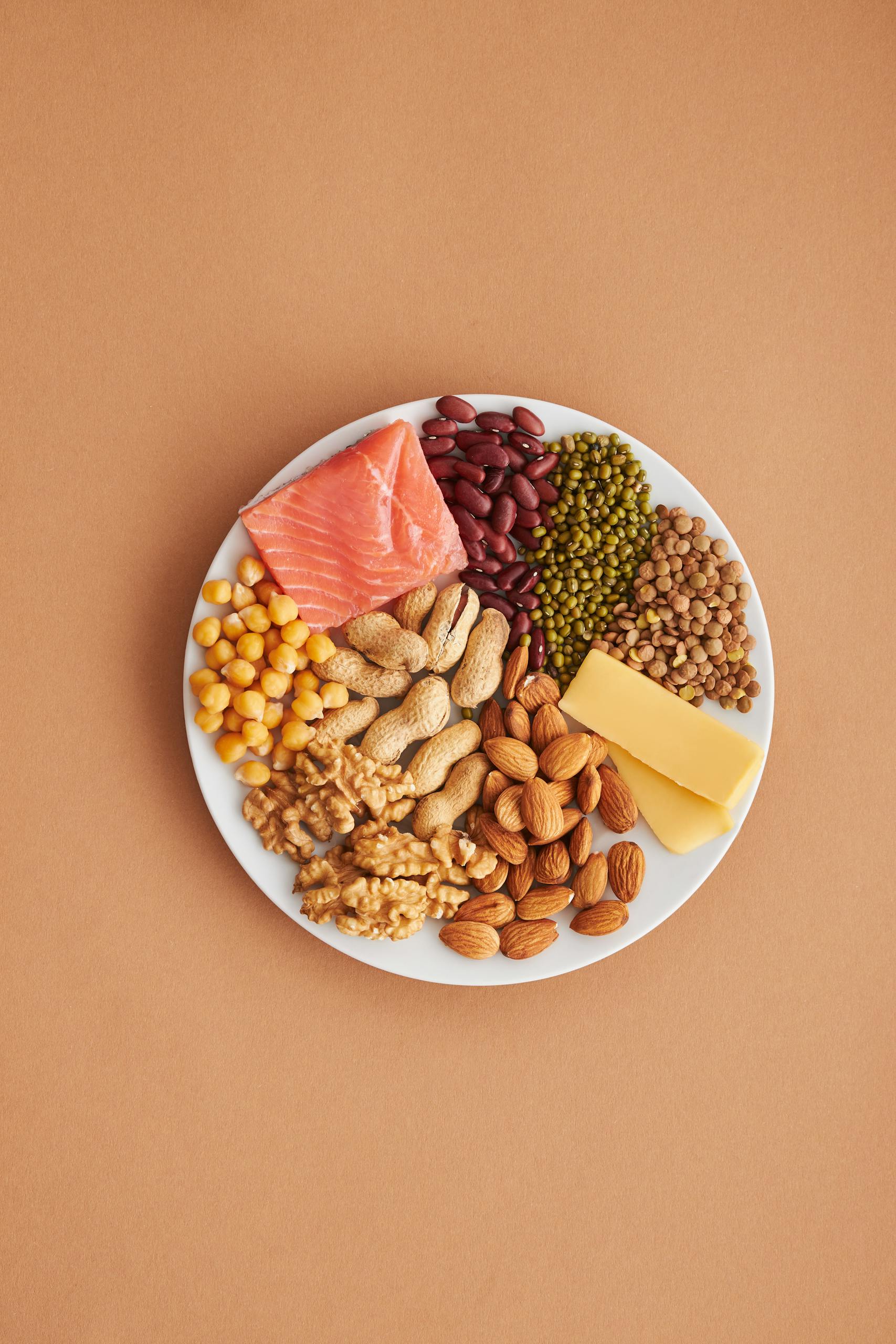 high-protein, high-fiber foods: Colorful assortment of proteins and legumes on a white plate, perfect for healthy eating inspiration.