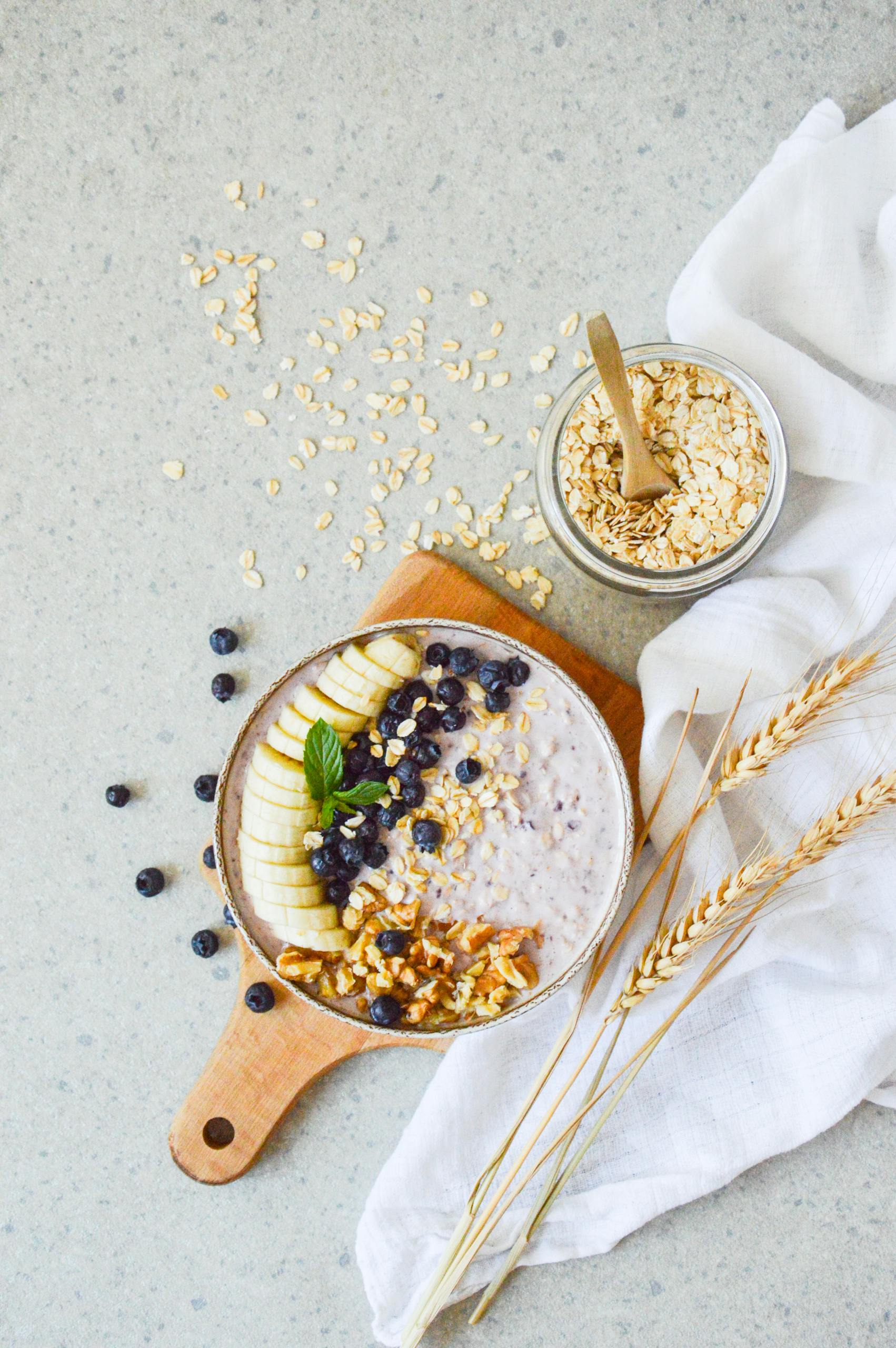 Healthy Fats for Breakfast: Delicious oatmeal bowl topped with banana, blueberries, and nuts, perfect for a healthy start.