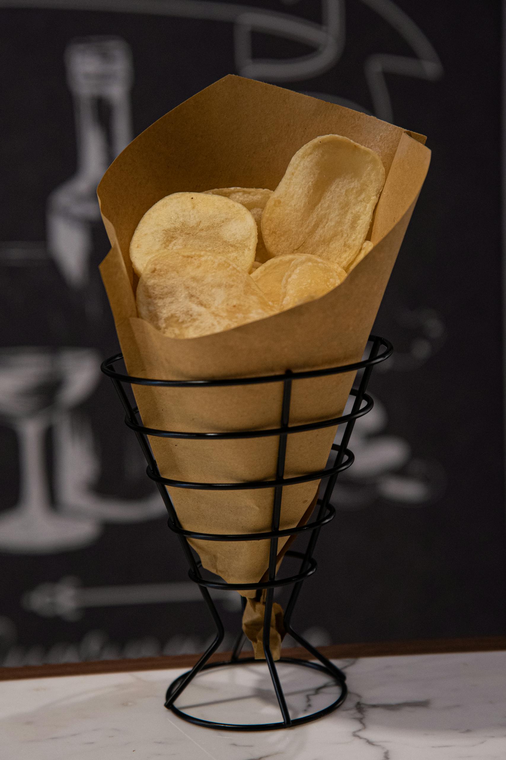 Are Ultra-Processed Foods Always Unhealthy: Golden potato chips in a wire basket with paper wrap, perfect for snack time.