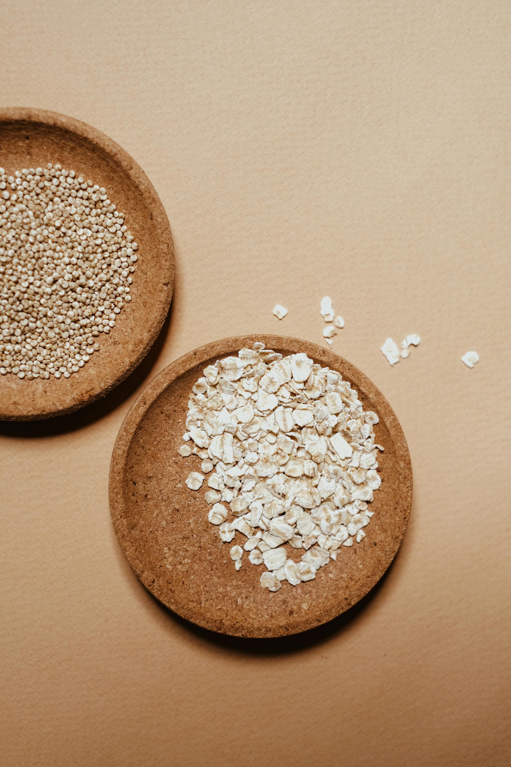 top plant-based iron foods: High angle shot of oats and grains in eco-friendly bowls on a brown background.