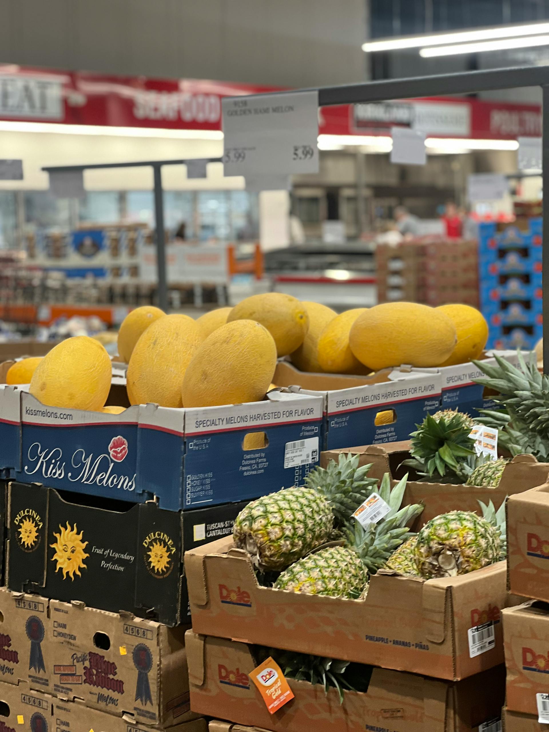 Healthy Costco Snacks: Selection of fresh melons and pineapples on display at a grocery store.