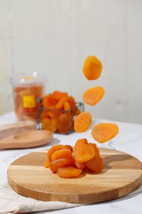 top plant-based iron foods: Vibrant dried apricots artistically displayed on a wooden board, perfect for culinary content.