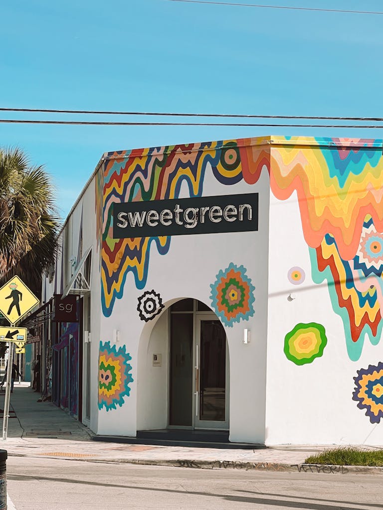 Healthiest Sweetgreen Orders: Vibrant Sweetgreen restaurant exterior with artistic mural in a sunny urban setting.