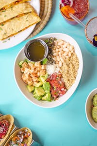 how to eat more fiber without bloating: Colorful Mexican-inspired bowl with beans, avocado, and quinoa.