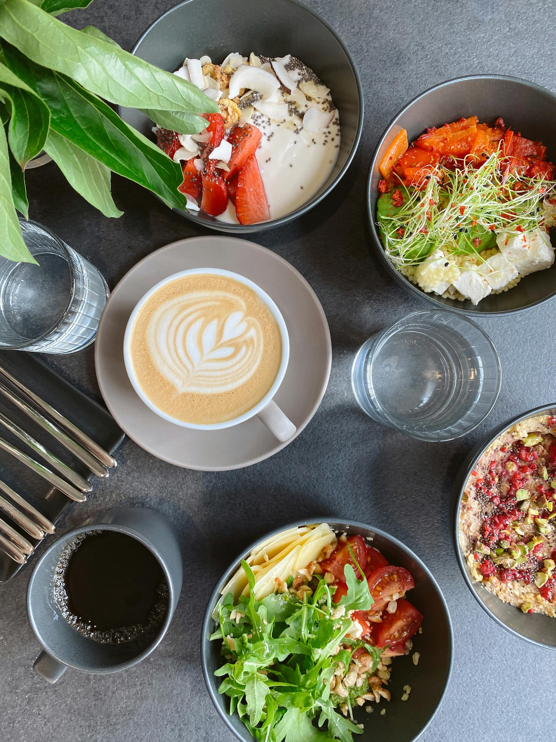 healthy eating myths: Top view of a vibrant breakfast assortment featuring coffee art, fresh salads, and desserts.
