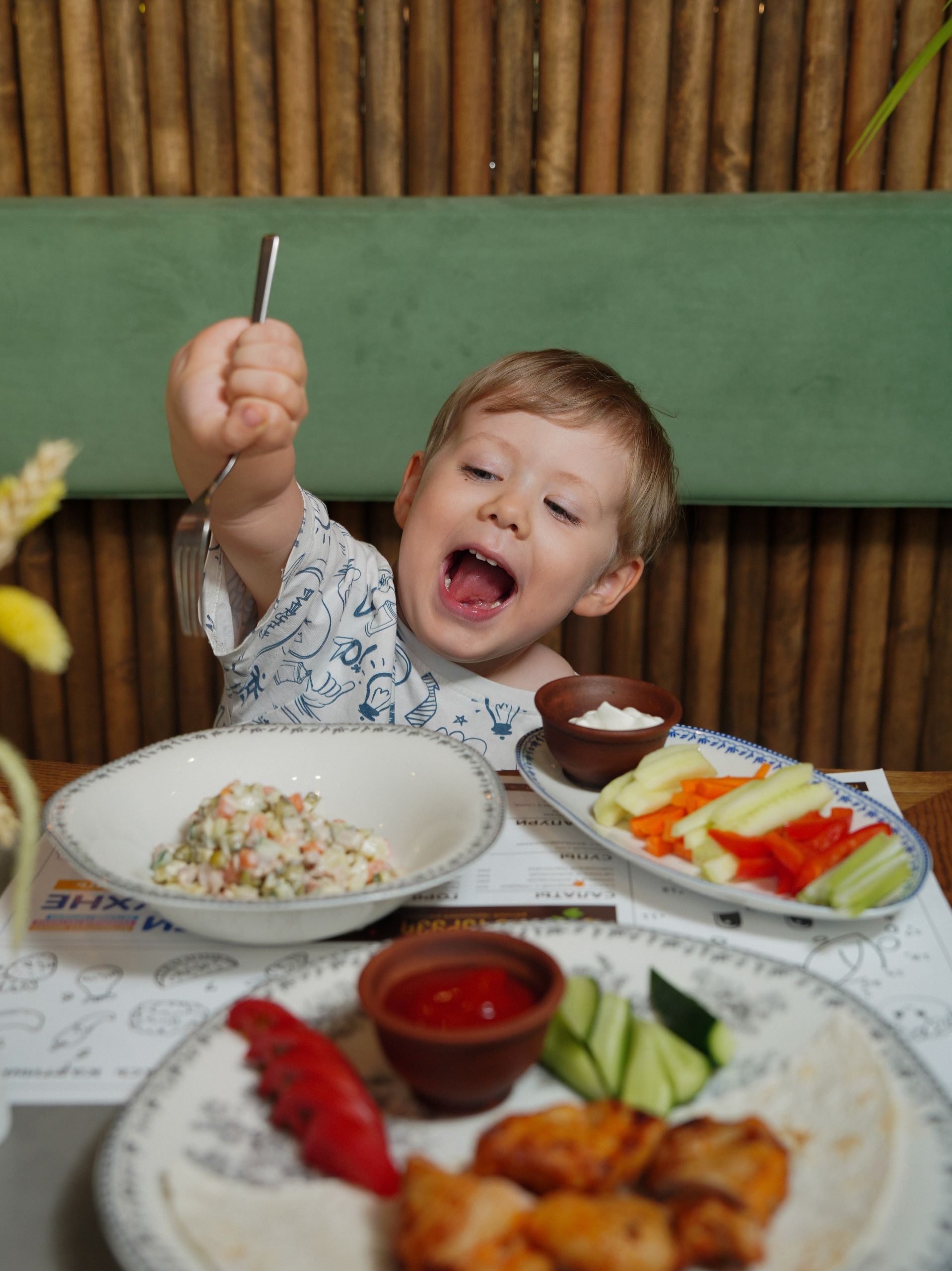 How to Get Your Toddler to Eat Vegetables: A cheerful child eagerly eating a healthy meal with vegetables and dip, creating a joyful moment.