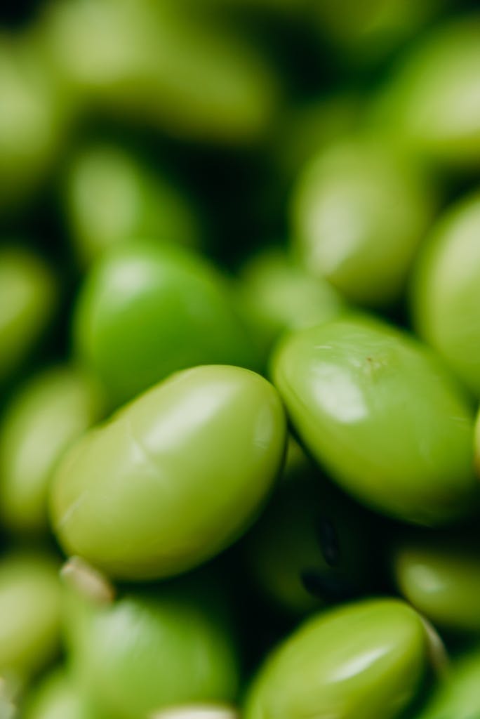 is soy bad for you: A detailed close-up of raw green edamame beans, showcasing their fresh texture.