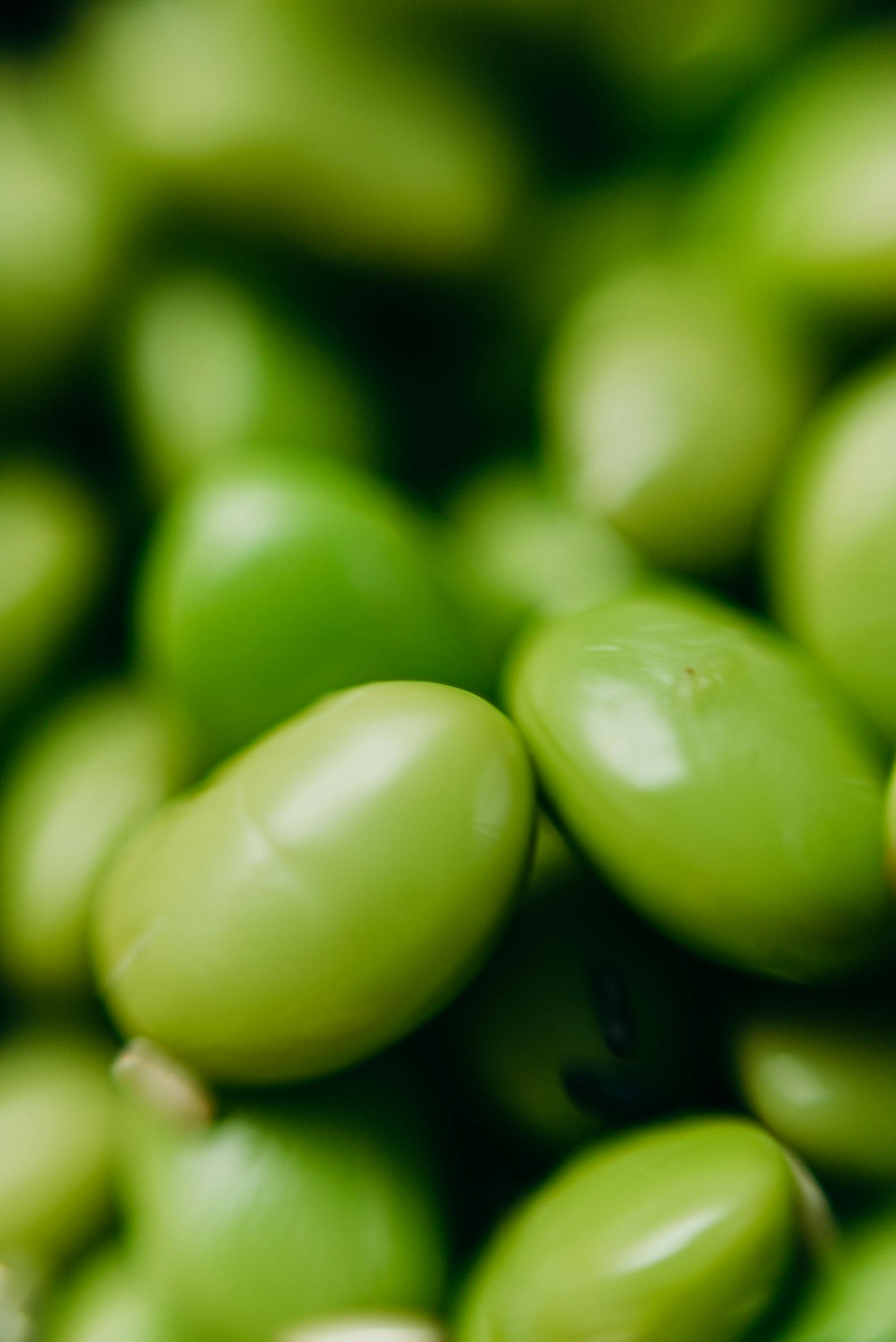 is soy bad for you: A detailed close-up of raw green edamame beans, showcasing their fresh texture.