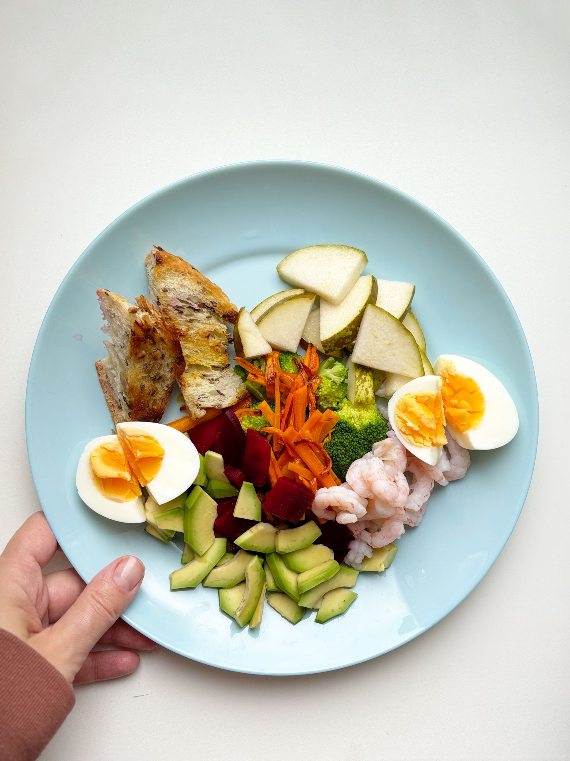 What to Eat During Menopause: A vibrant plate featuring shrimp, eggs, vegetables, and fruits, perfect for a nutritious meal.