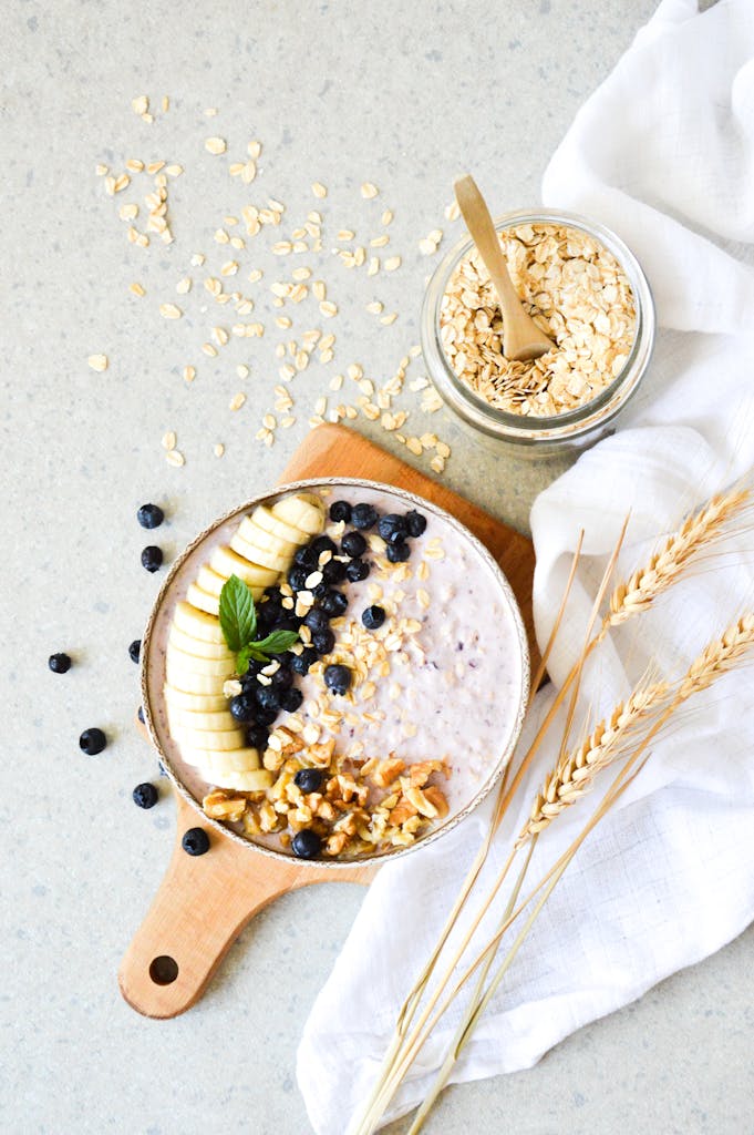 Easy Protein Swaps for Weight Loss: Appetizing breakfast bowl with oats, banana, blueberries, and walnuts on a light background.