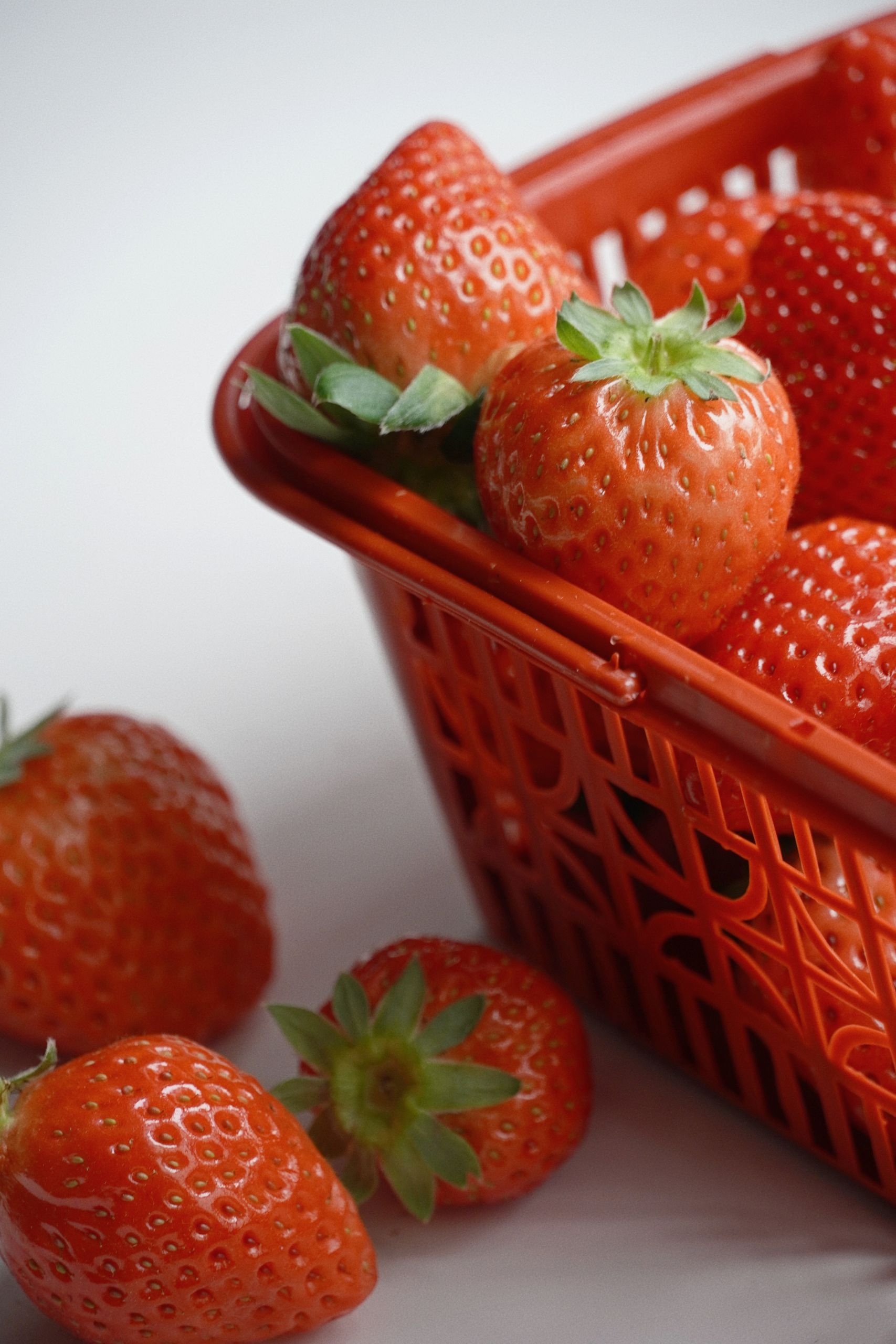 Strawberry Nutrition Facts and Benefits: Close-up of ripe strawberries in a red basket, emphasizing freshness and vibrant color.