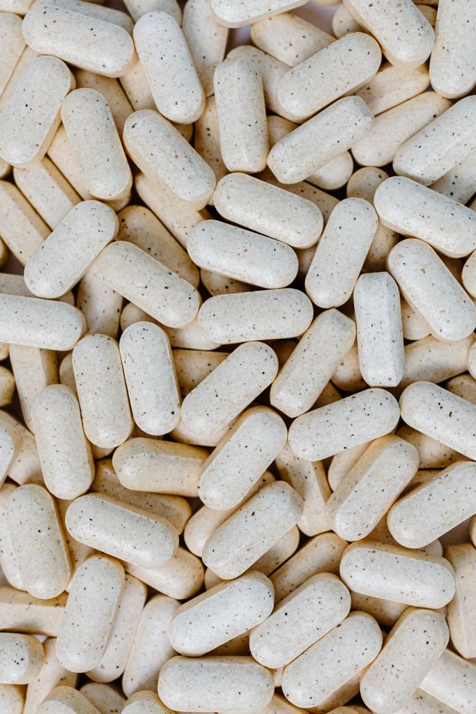 do you need a multivitamin: Detailed close-up of numerous white pills, showcasing texture and shape.