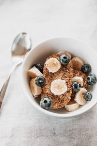 daily habits for better gut health: A healthy cereal breakfast bowl with banana slices and blueberries.