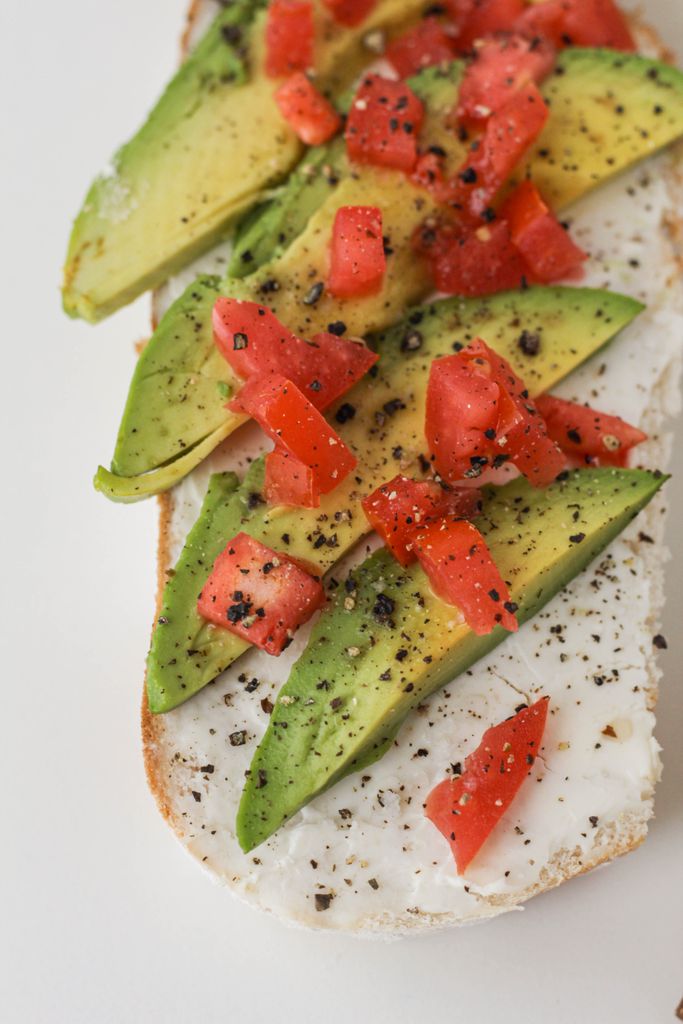 Best Foods for Muscle Gain: Delicious avocado toast topped with tomatoes and black pepper on a white bread slice.