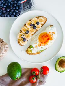 best breakfast for blood sugar control: Delicious breakfast featuring avocado toast and fresh fruit on a white plate.